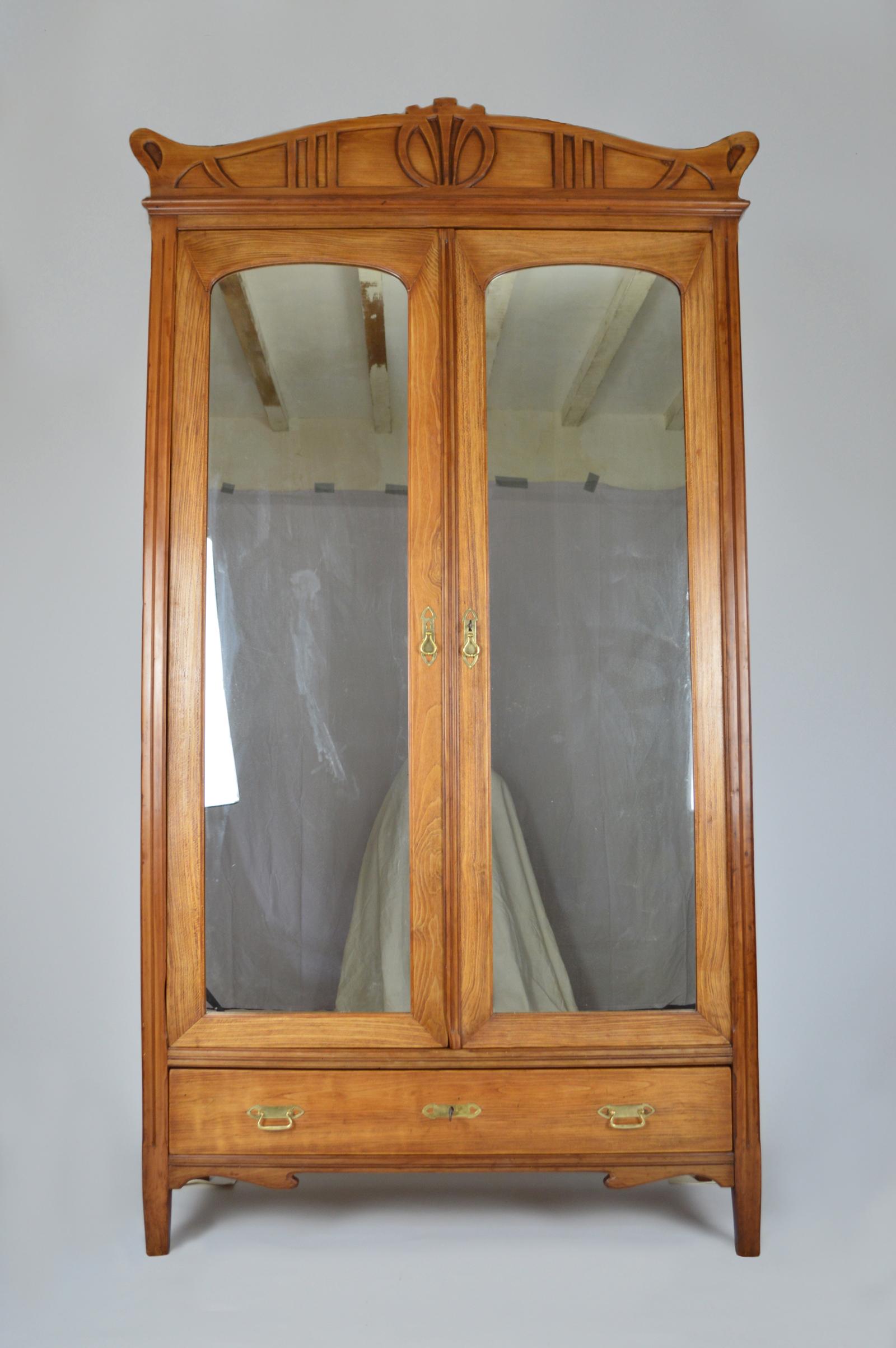 Beautiful Art Nouveau wardrobe.
In light tone carved fruit wood, sorbus or pyrus.
1 closet with 2 mirrored doors containing 1 shelf.
1 drawer.
Handles and keyholes made in brass, heart them.
Keys and locks present, in good working