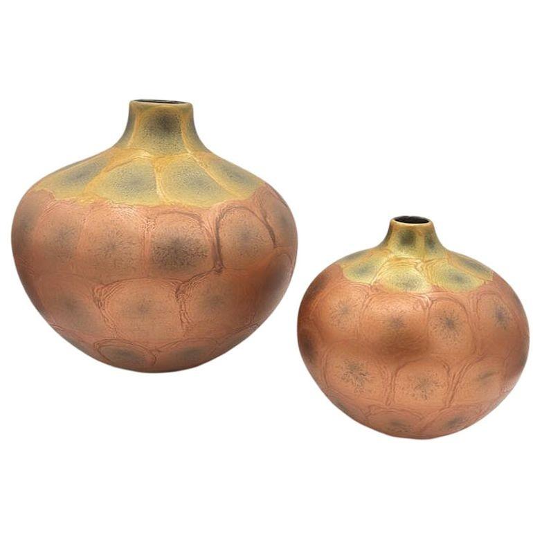 Coppia originale di vasi in stile Art Nouveau cotti al raku, che ricordano il design di Weller Pottery e che incantano con il loro smalto iridescente a doppia tonalità. Il processo di cottura Raku conferisce motivi unici e imprevedibili e un