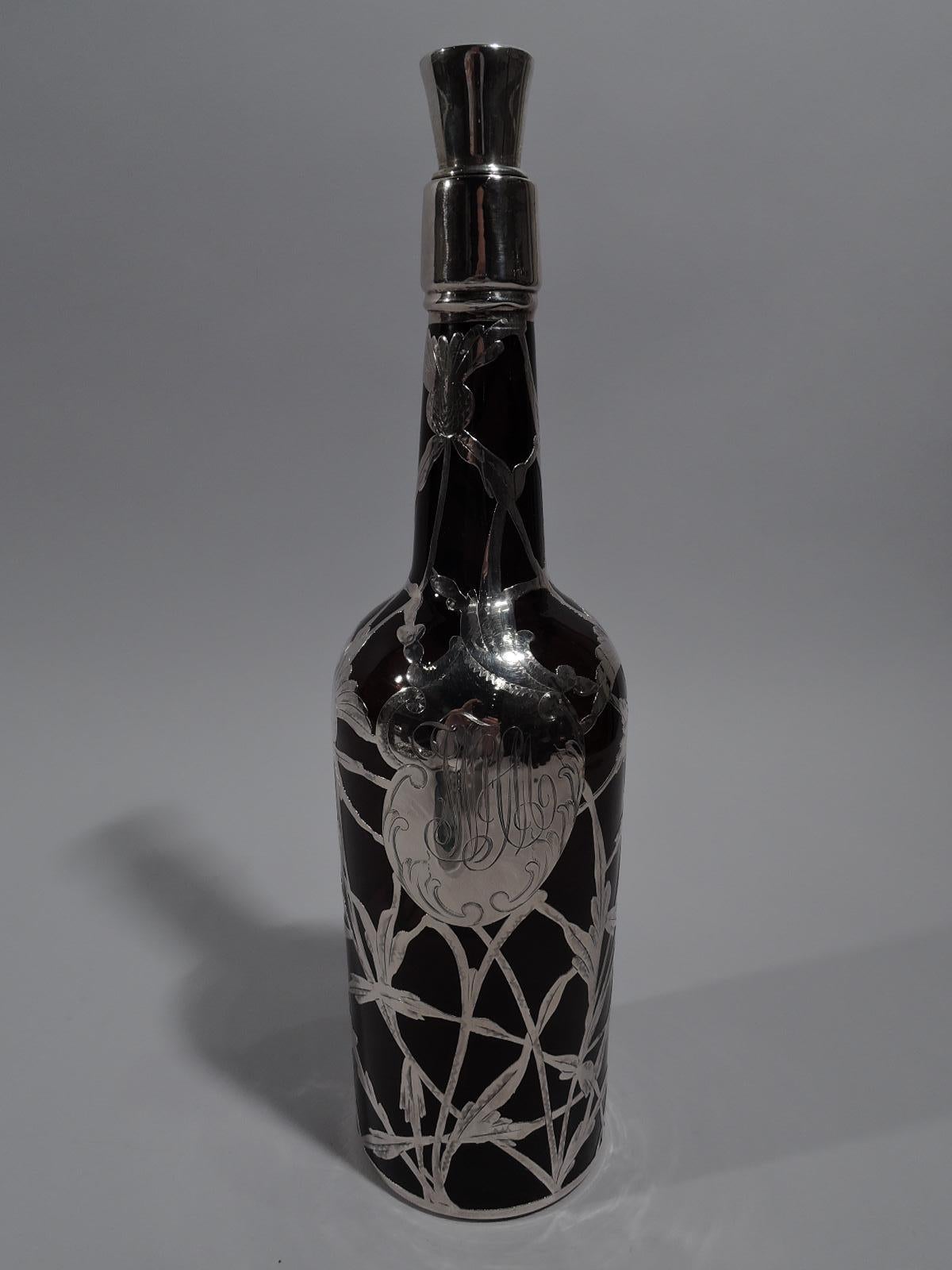 Art Nouveau amber glass whiskey bottle decanter with silver overlay, circa 1900. Traditional cylindrical form with sloping shoulder and upward tapering neck. Open and interlaced silver overlay with thistle ornament and asymmetrical cartouche with