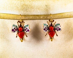 Orecchini a leva in oro giallo con diamante bianco e smeraldo, rubino rosso e corallo.