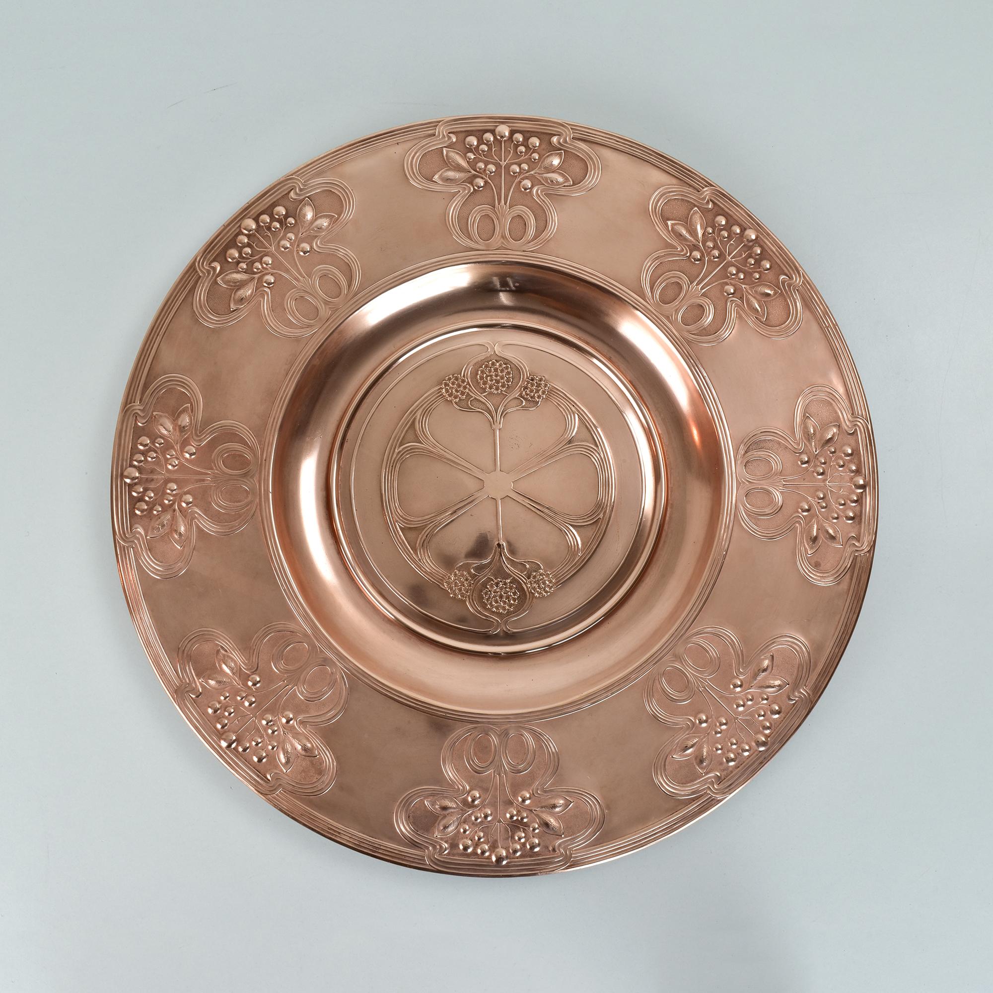 Dieser auffällige Wandteller aus Kupfer wurde von der WMF (Württembergische Metallwarenfabrik) um 1900 hergestellt, also in der Hochphase des Jugendstils und des Kunstgewerbes. Das Design zeigt ein für die Ästhetik des Jugendstils