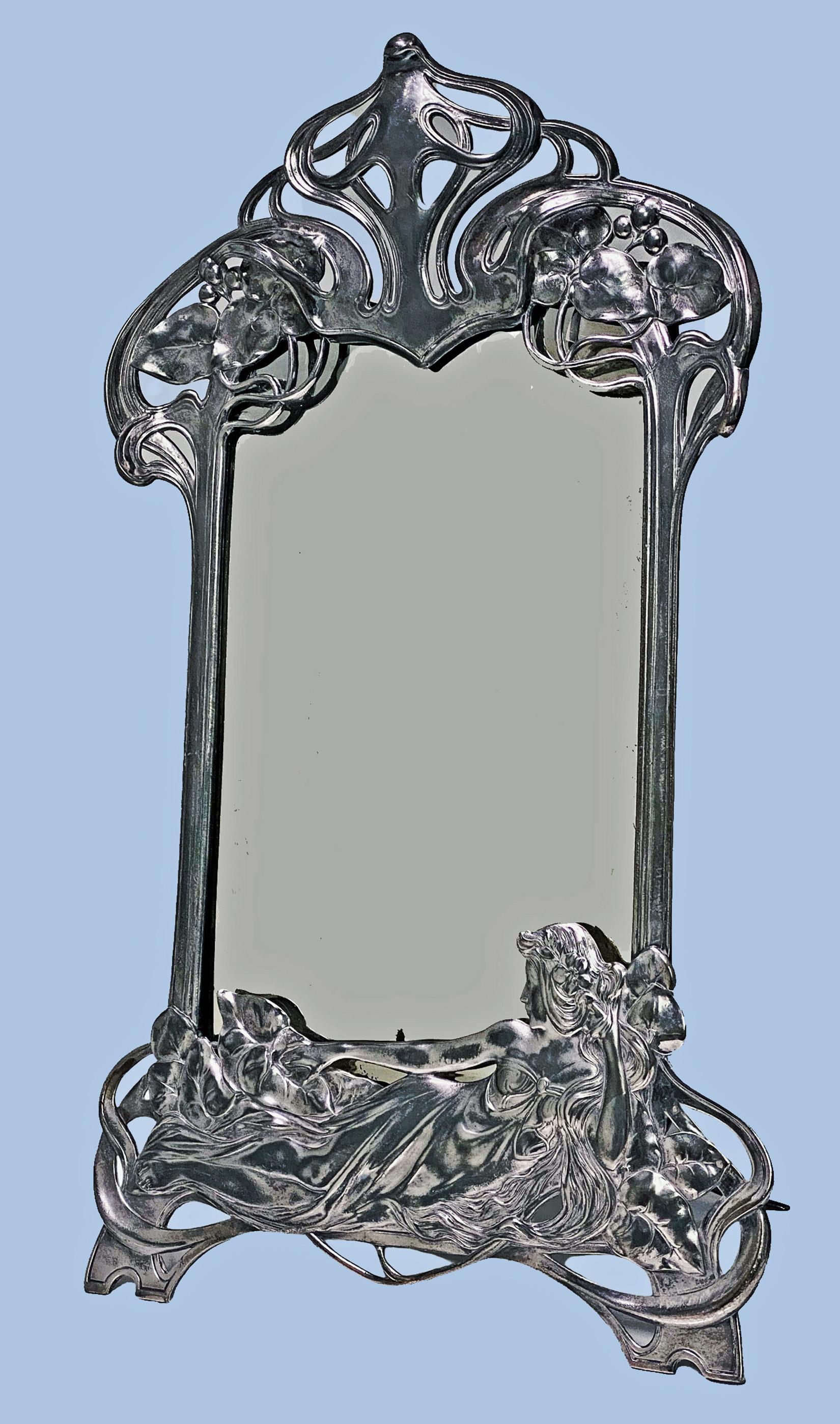 Art Nouveau WMF Mirror, circa 1906, Germany, silver plated, pattern number 108a. Original beveled glass mirror and wood back, the frame decorated with openwork foliage and a reclining maiden in shallow relief, easel support, stamped maker's marks