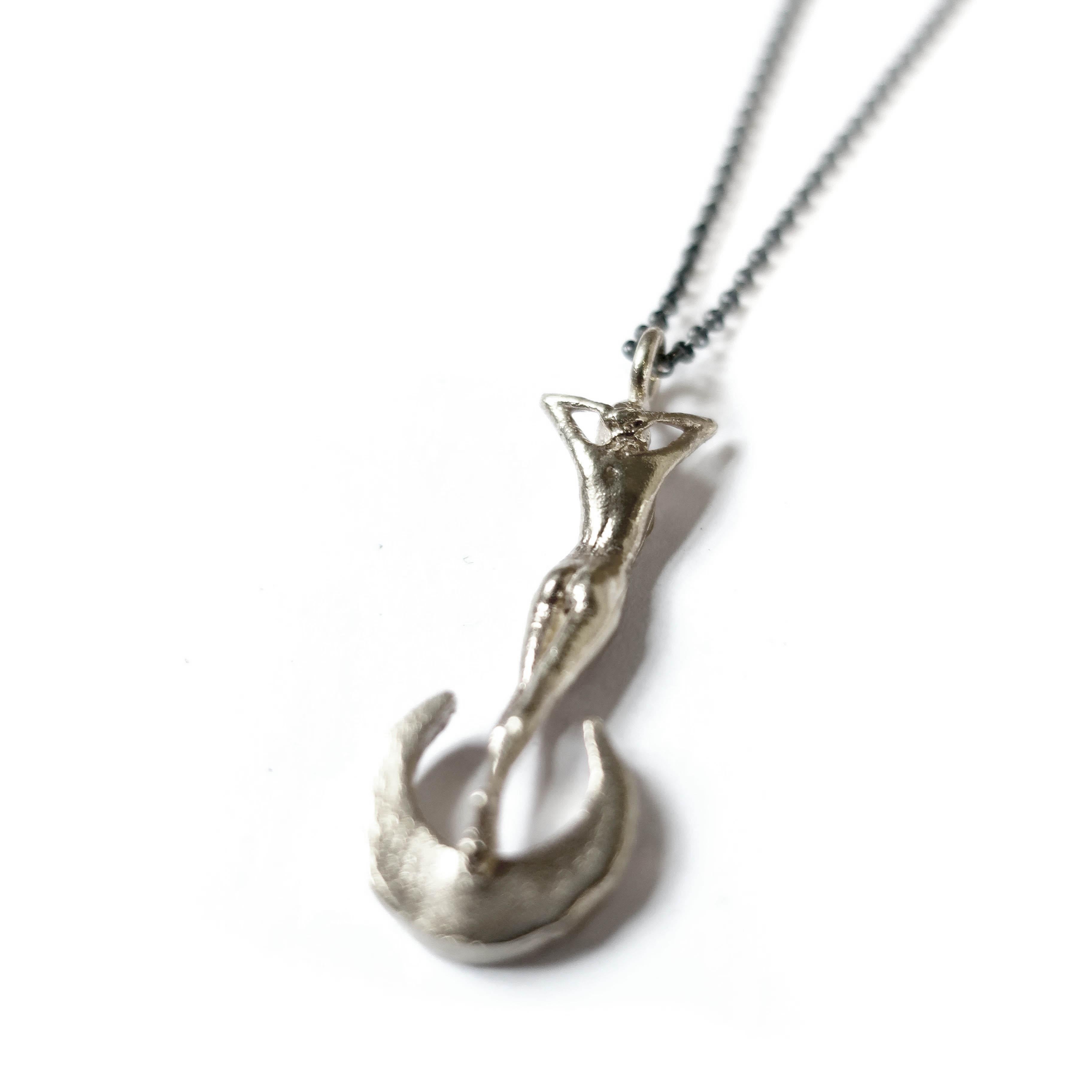 Cast in solid 14k white gold this statuesque woman perched atop a crescent moon is a stunning ode to classic art nouveau themes in jewelry. Strung on a solid 20 inch twisted rope chain this pendant measures 33mm in height.  The moon is bead set with