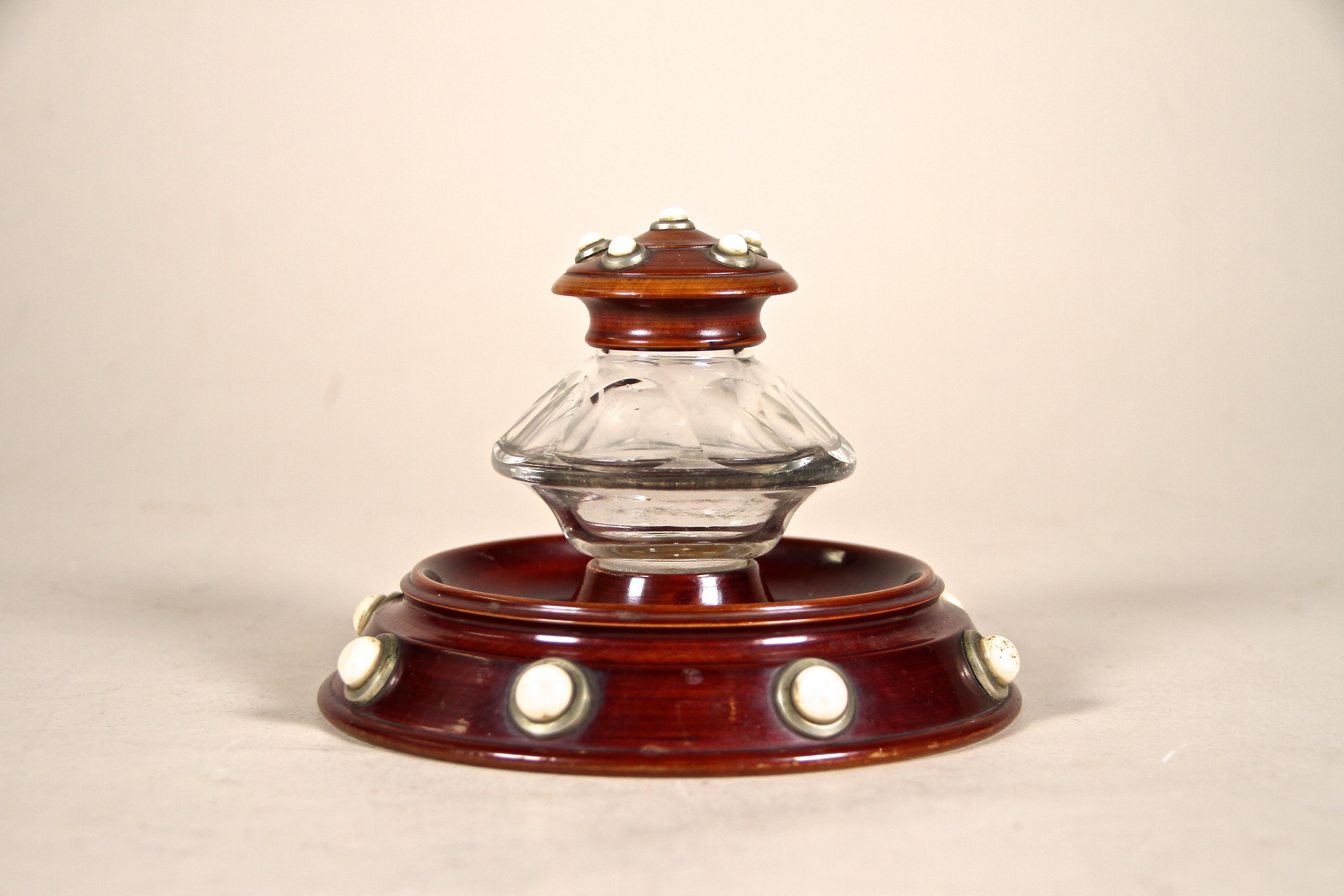 Out of the ordinary wooden Art Nouveau Inkwell from around 1900 in Austria. Artfully carved out of beechwood and trimmed to a nice mahogany look, this unusual round inkwell shows a fantastic design adorned by brass rosettes with porcelain knobs on
