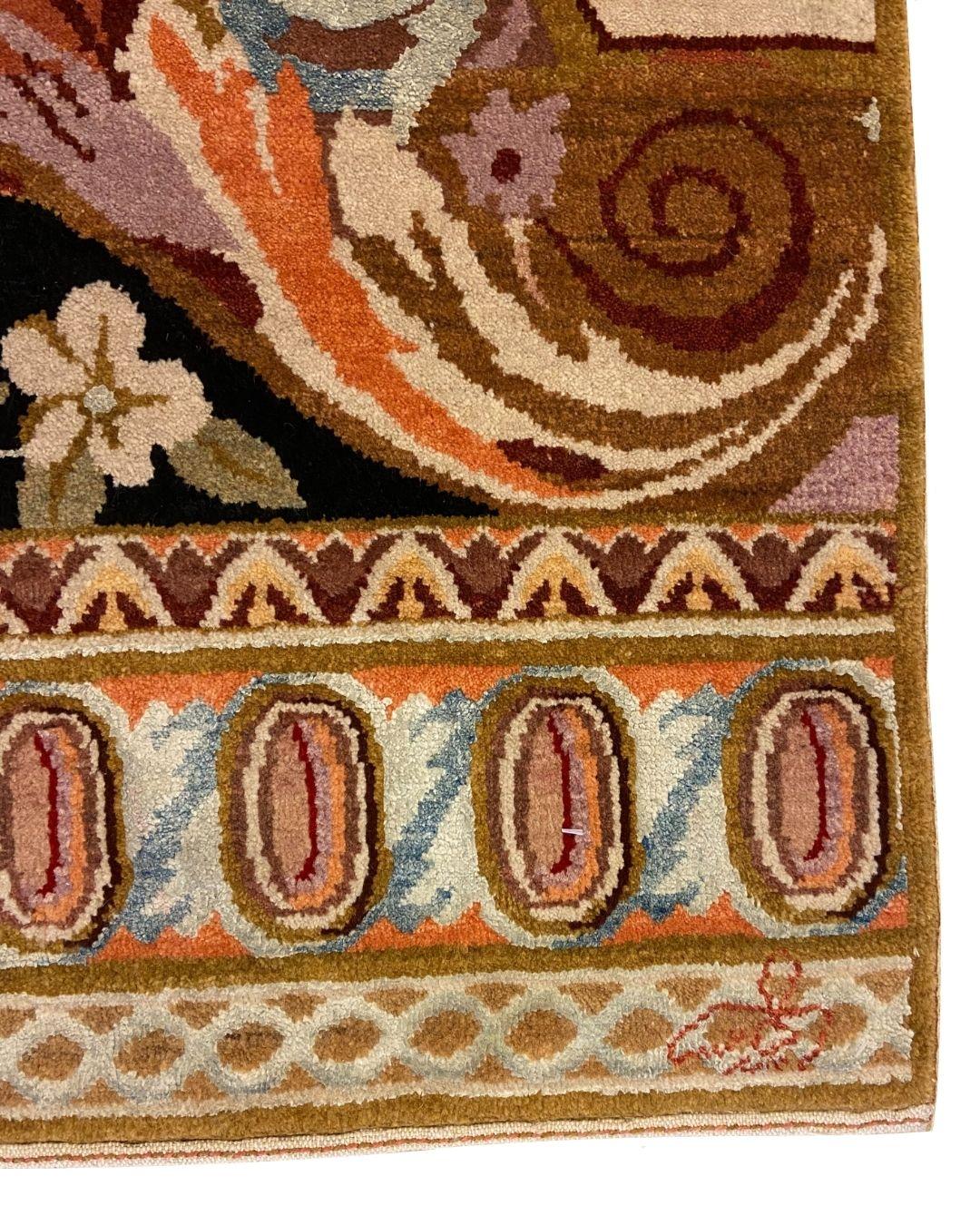 This Art Nouveau wool and silk Persian rug showcases a vibrant and sophisticated blend of coral, red, purple, brown, and blue hues. The design draws inspiration from the fluid, organic lines characteristic of the Art Nouveau movement, with floral
