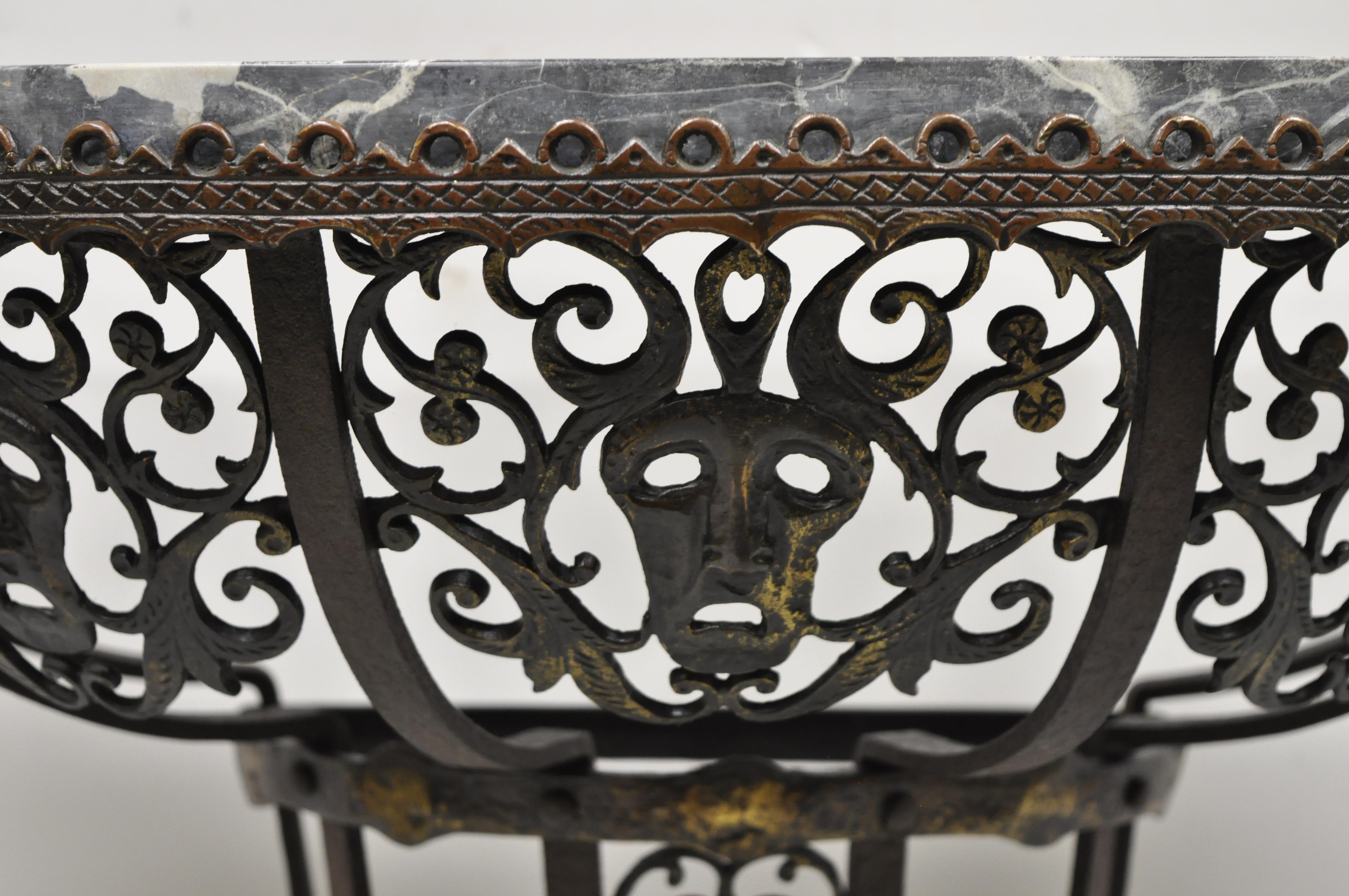 Antique French Art Nouveau wrought iron figural half round demilune marble top console hall table with faces after oscar bach. Item features half round marble top, pierce decorated faces to skirt, wrought iron construction, very nice antique item,