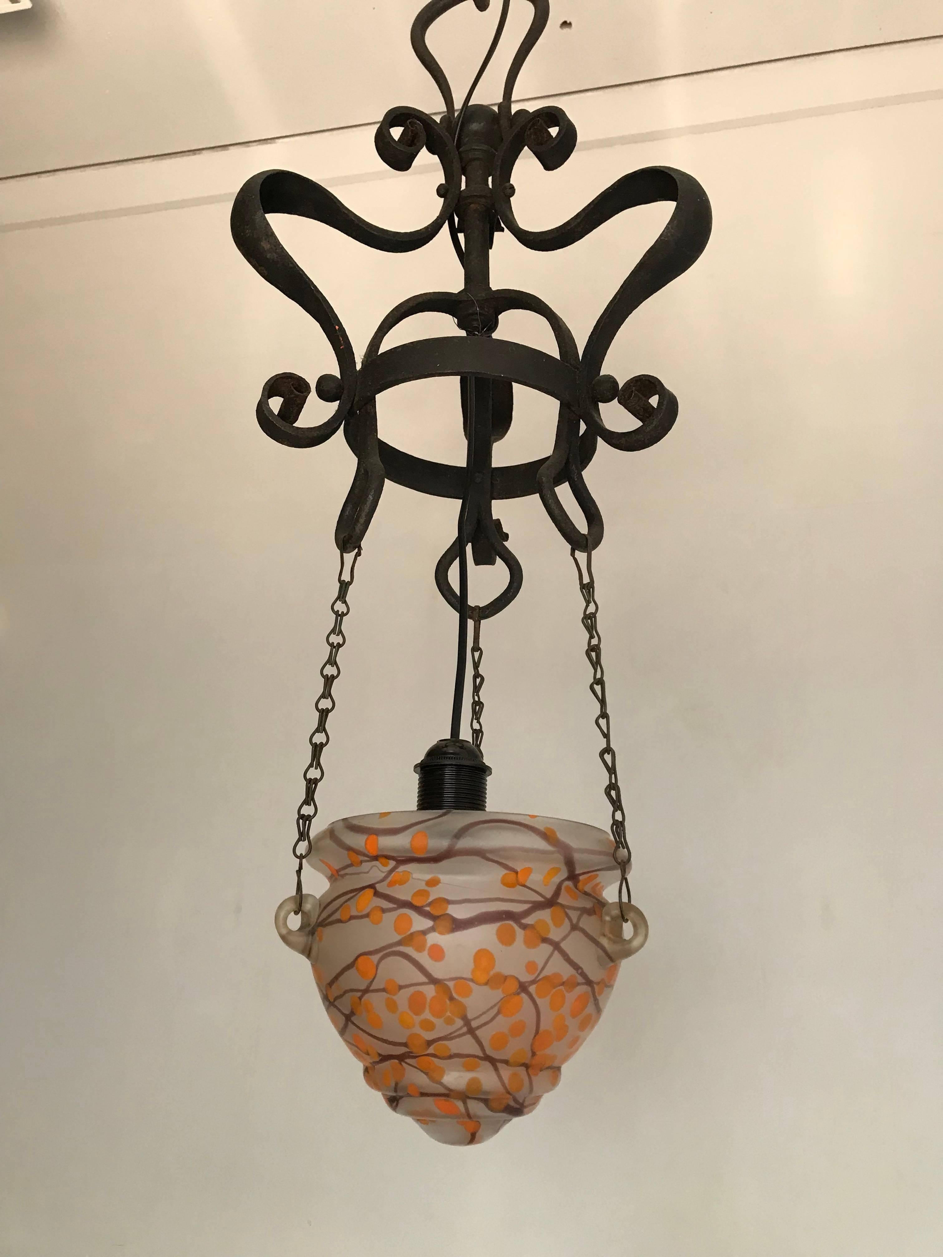 Pure and elegant work of lighting art from the turn of the century.

The handforged and extremely elegant shape of the wrought iron top of this pendant is litereally like the crown on top. The perfect symmetry and the perfect curves in the wrought