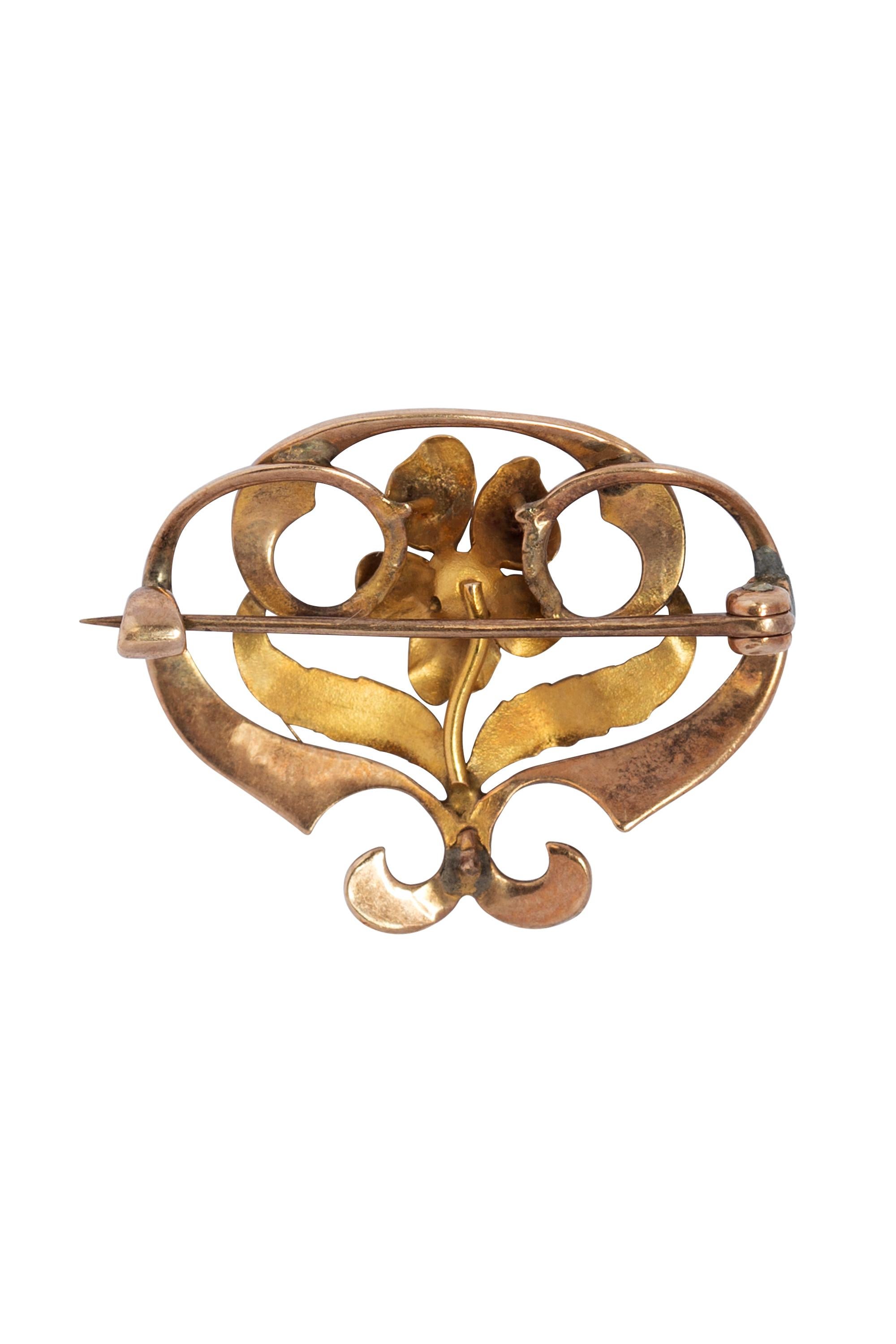 This exquisite Art Nouveau flower brooch pin is a true testament to the romantic and natural style of the era. Crafted in 14k yellow gold, the swirling frame and finely engraved leaves add a touch of elegance to the soft-petaled posey