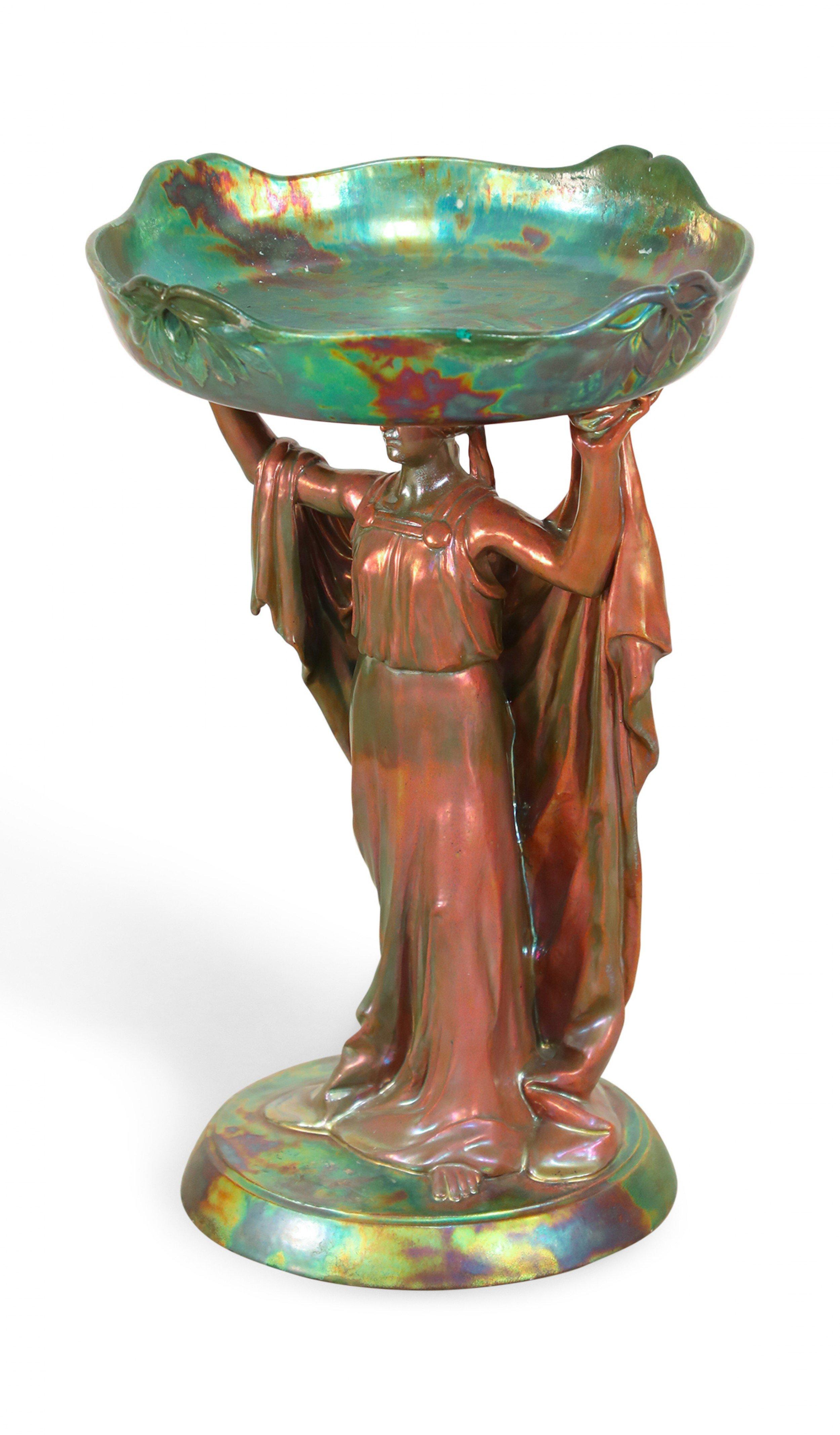 Art Nouveau Zsolnay porcelain green iridescent centerpiece with female figure holding round tray above head.
       