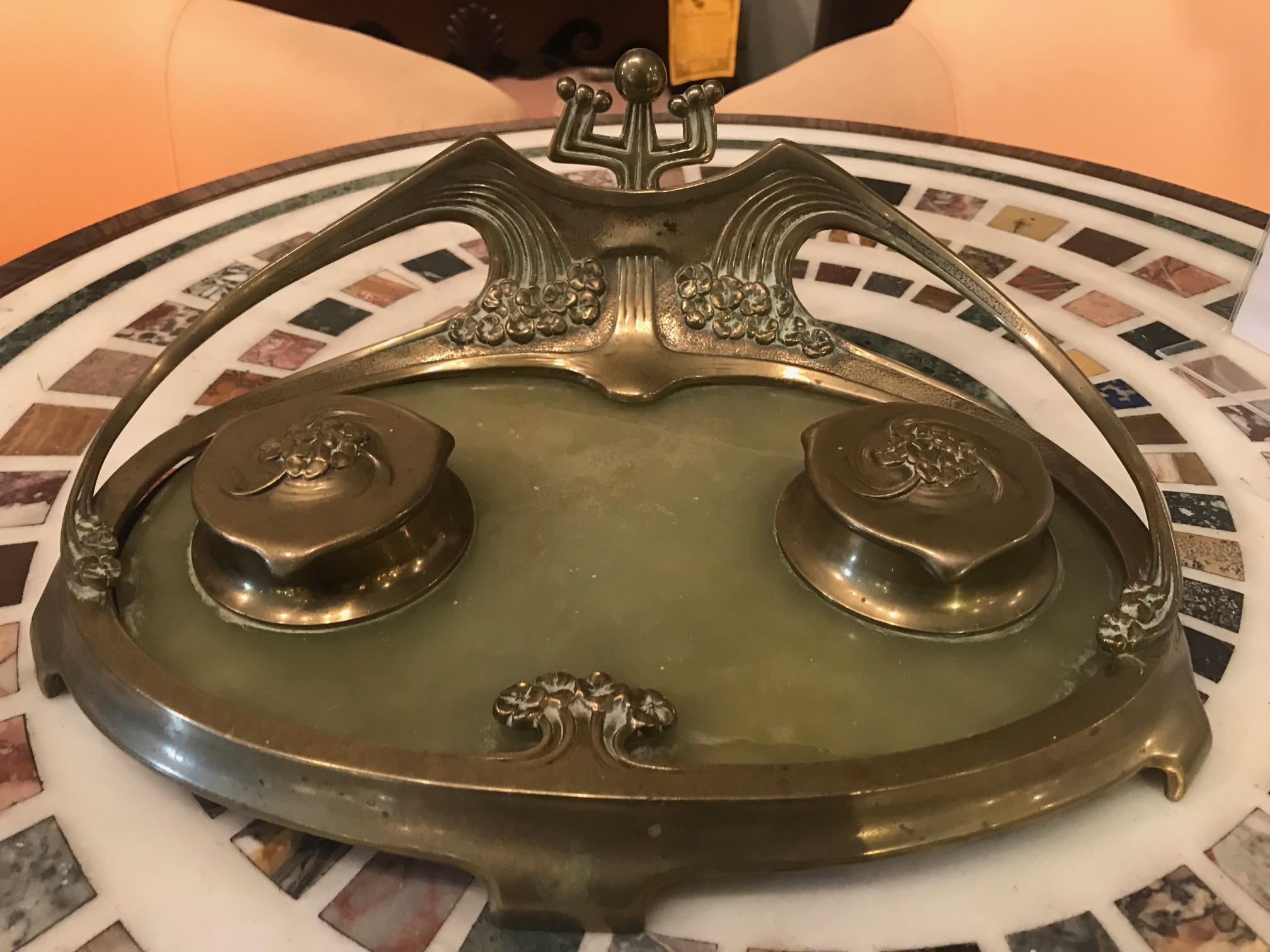 Art Nouveau brass and green marble desk set with two original moulded white porcelain inkwells, repair to one, in the manner of Herman Eichberg, circa 1900.