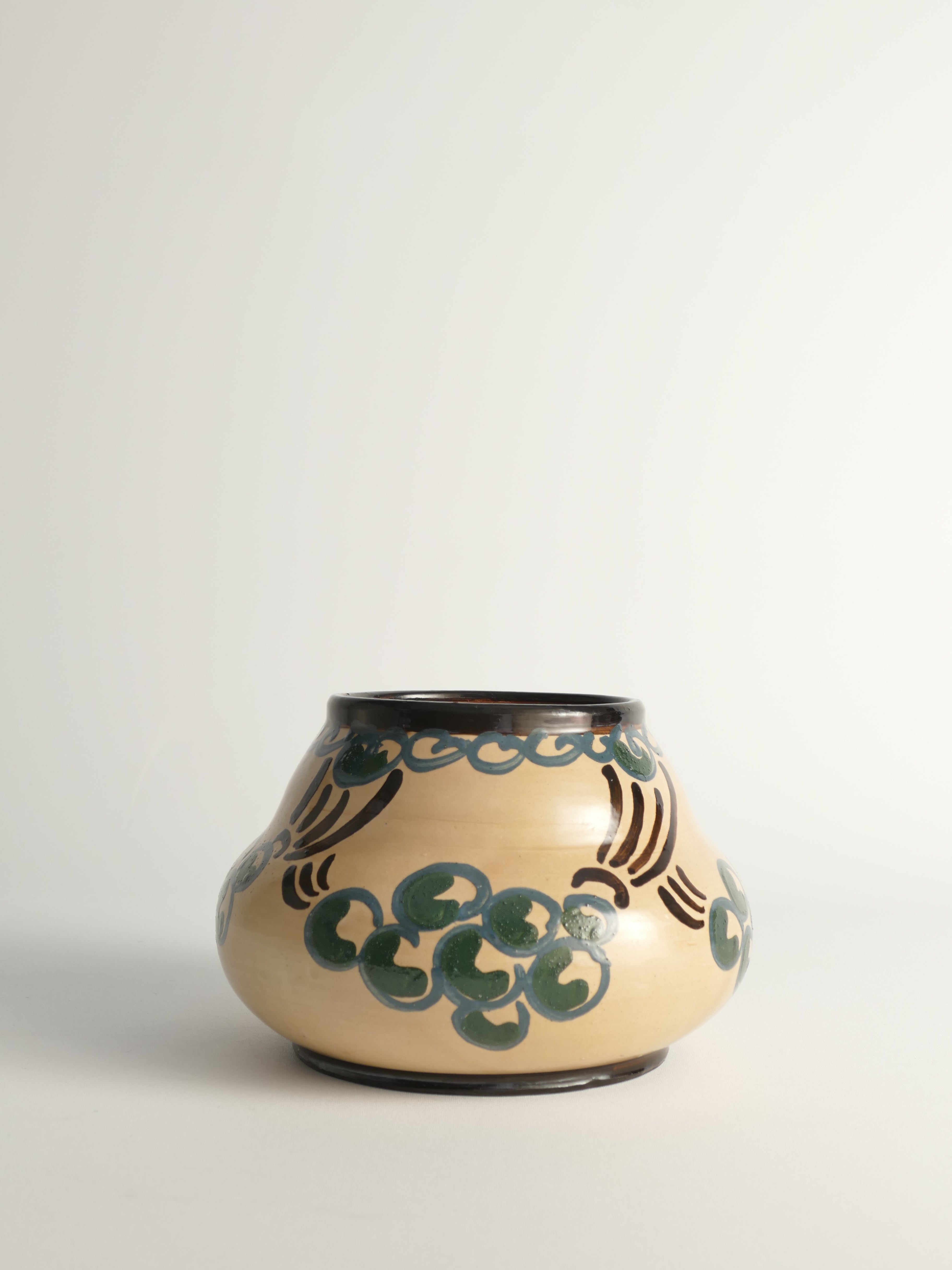 This exquisite gourd-shaped art nouveau vase is created at ST. ERIKS LERVARUFABRIKER, a legendary pottery factory based in Uppsala, Sweden. Created between 1910 and 1920, this piece embodies the elegance of the Art Nouveau movement with its organic