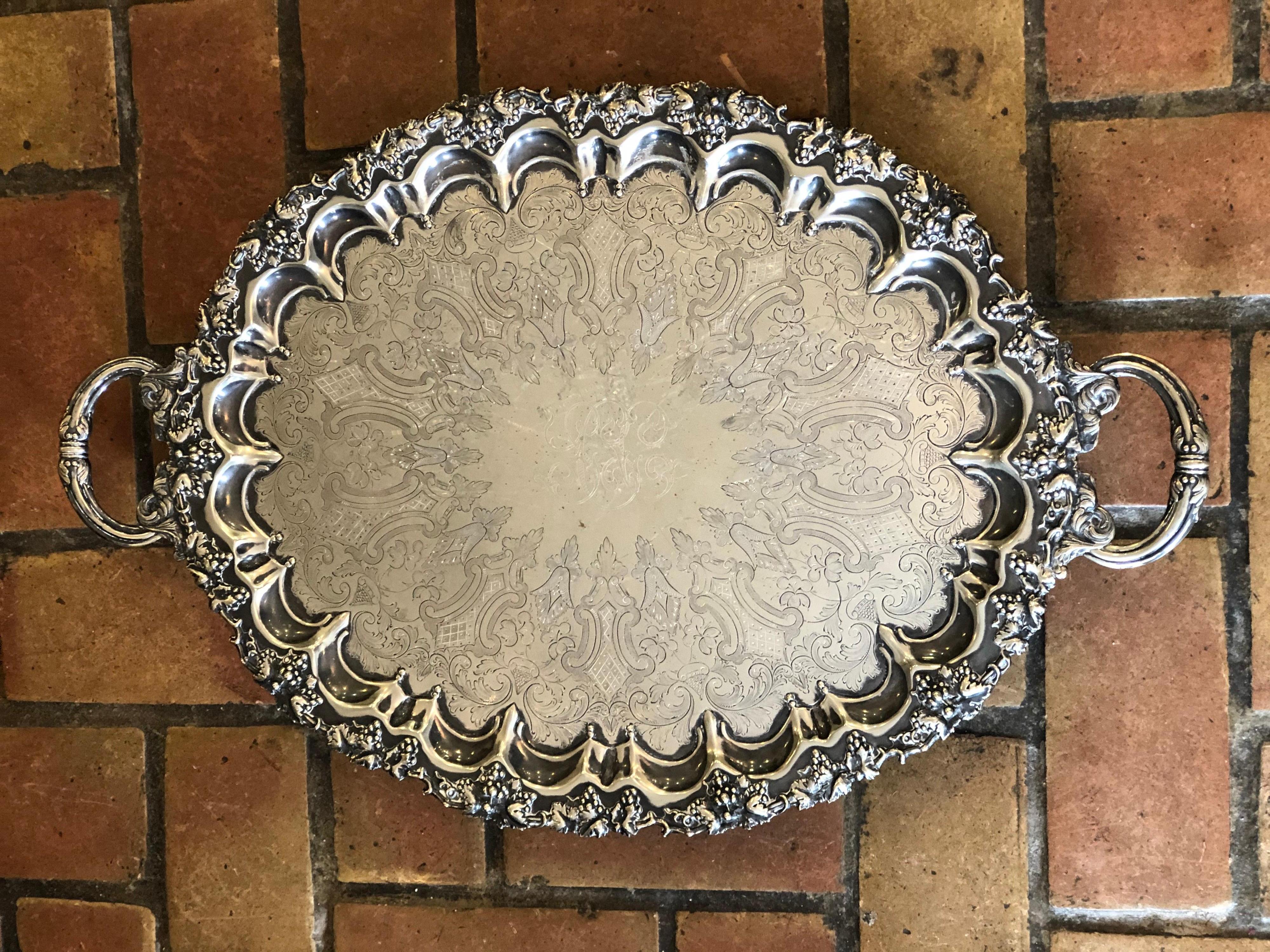 Art Noveau silver plated oval serving tray by Singleton, Benda & Co Ltd. 
Early 1900-1910. Stamped on bottom with initials. S.B and Co. London England
Highly embossed footed tray in a repousse style with elaborate handles and highly decorated