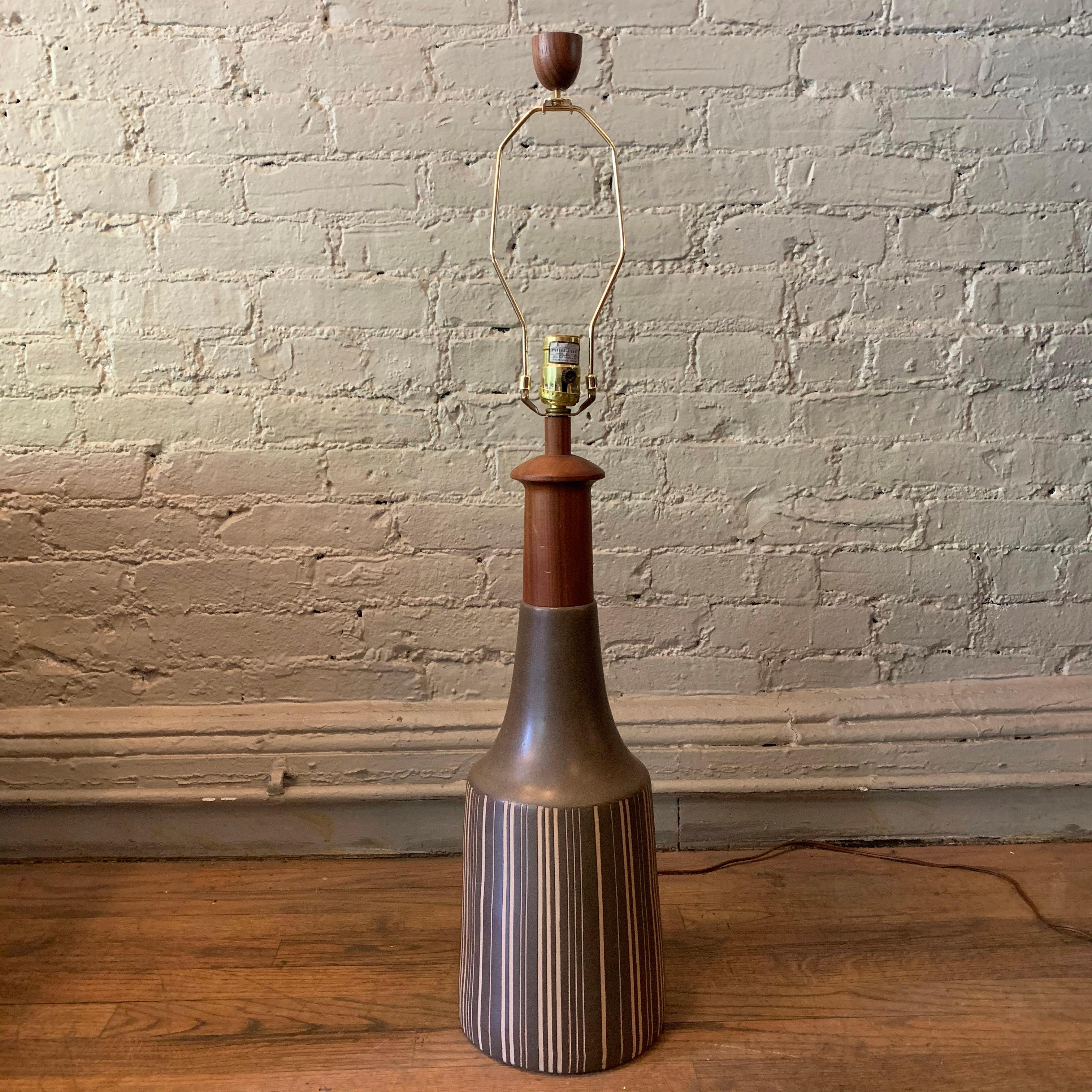 Large, art pottery table lamp by Gordon Martz for Marshall Studios features a muted gray, striped base with teak neck and finial. The lamp is 24.5 inches height to the socket.