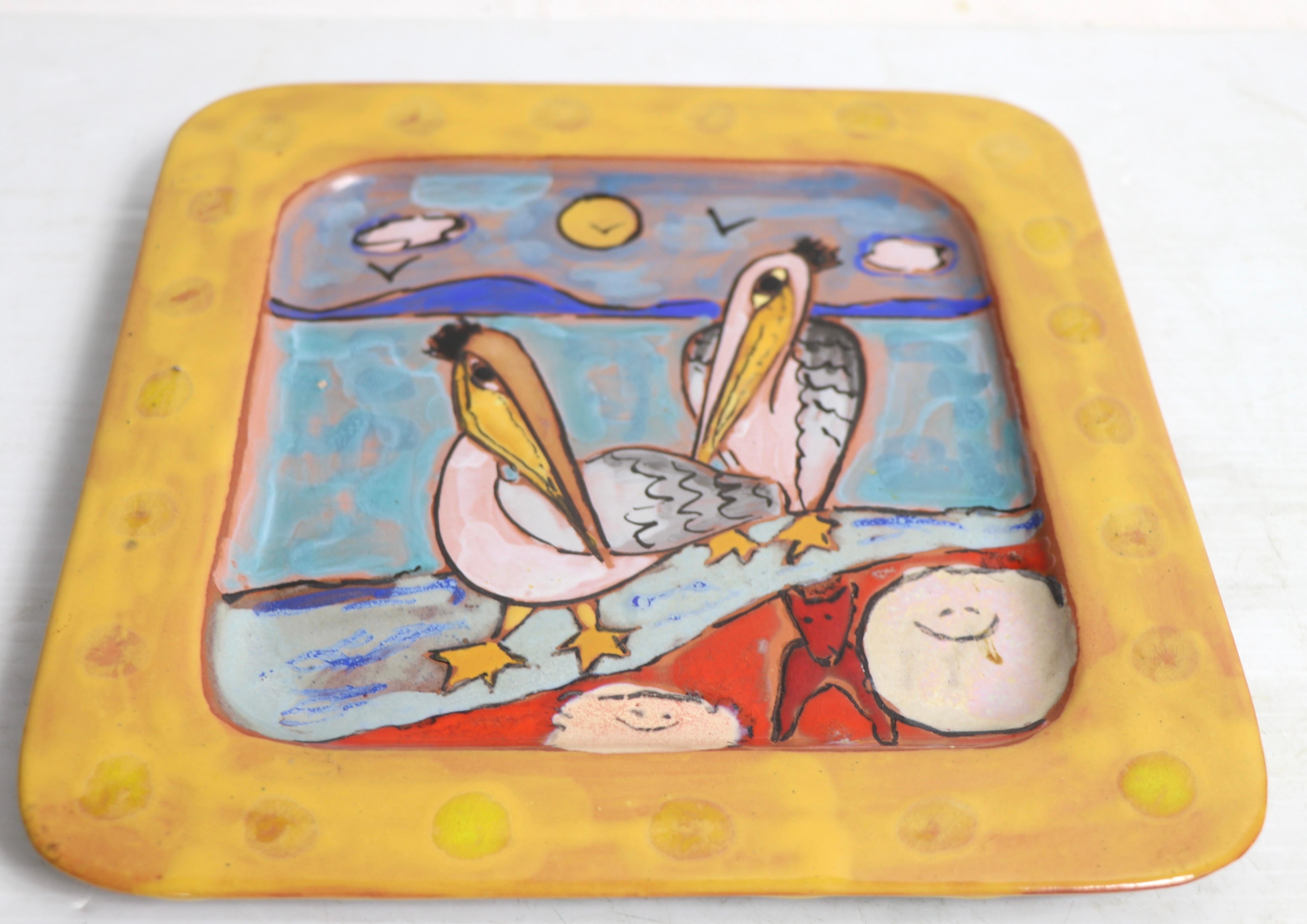 Exceptional art pottery plate by noted ceramicist Martine Azema, Made in Vallauris France, circa 1970's. The decorative plate depicts two stylized pelicans, and a red dog, along the shore. Fully and correctly marked on verso, as shown. This example