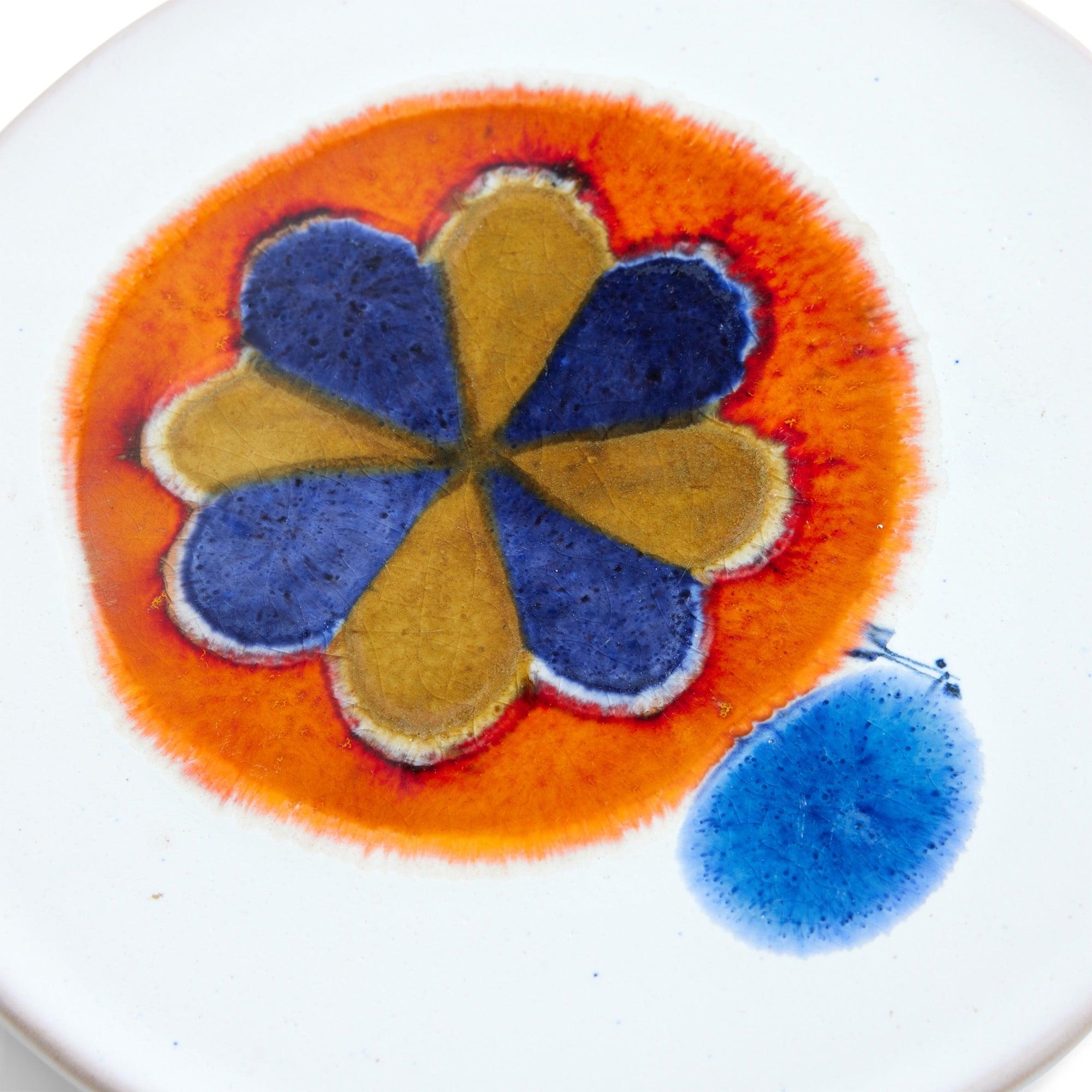 Assiette en poterie d'art au design abstrait en forme de soleil, réalisée par le studio suisse Rabiusla Herrliberg.