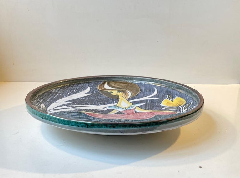 Large Delicately glazed charger dish or wall platter in sgrafitto technique. Depicting a female in ballroom dress. It is hand signed Tilgmans, Sweden, indistinguishable initials/marking. It was probably made by Marian Zawadzki in the mid 1950s who