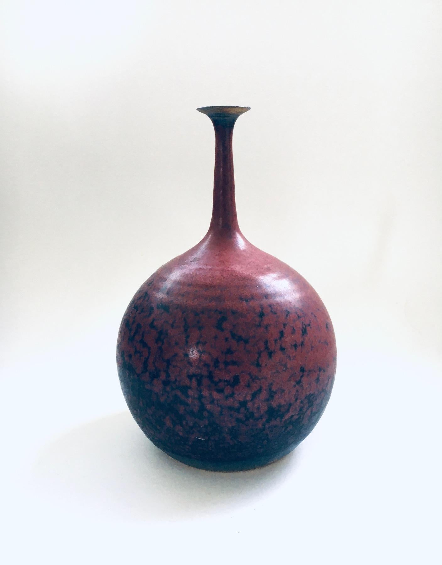 Vintage Art Pottery Studio Spout Vase by Gubbels Helden. Made in The Netherlands, 1970's / 80's period. Ball shaped vase with fine spout in bordeaux red and blue glazes. Stamped on the bottom. This comes in very good condition. Measures 24,5cm x