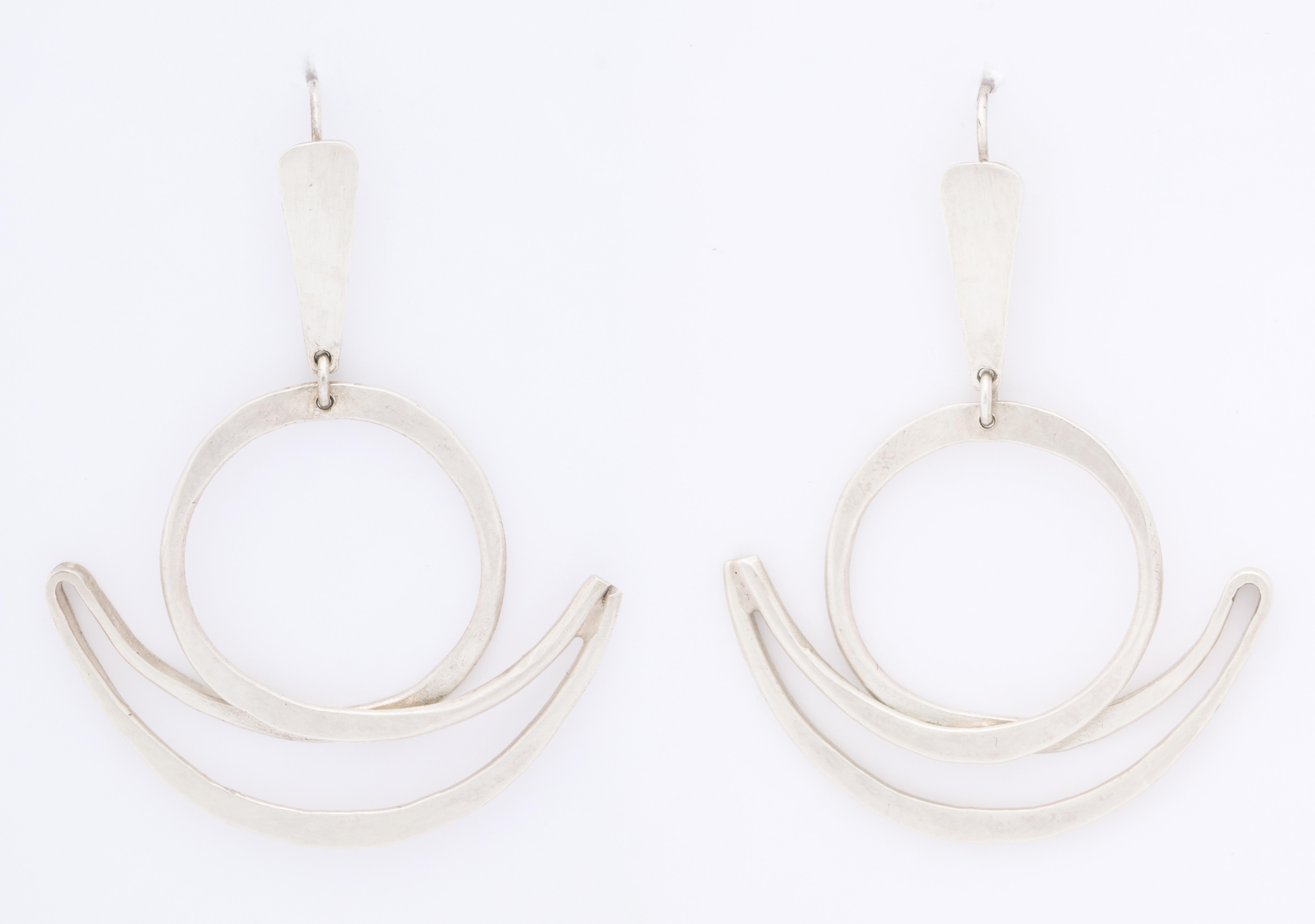 Large, rare form in signed Art Smith chandelier earrings have a solidity in the crescent and moon design. Art Smith is highly desirable, stops traffic at shows and to this day remains a famous African American Jewelry designer. 
Modernist silver