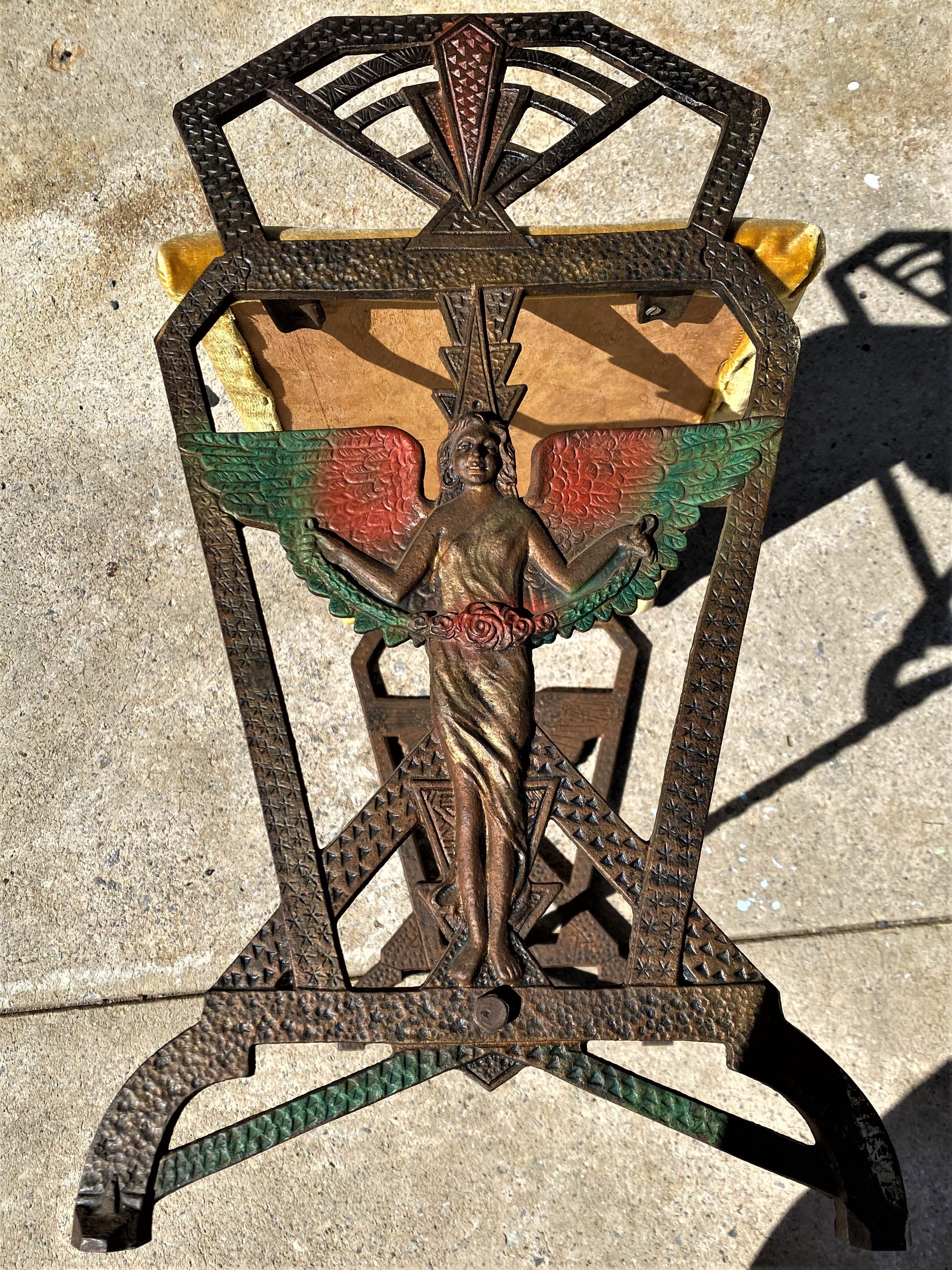 This is an absolutely fabulous art deco pattern bench with an amazing winged female figure in relief, draping a rose garland and topped with a radiating fan. The original colors, Bronze, orange, black & green, which were sprayed on are still vibrant