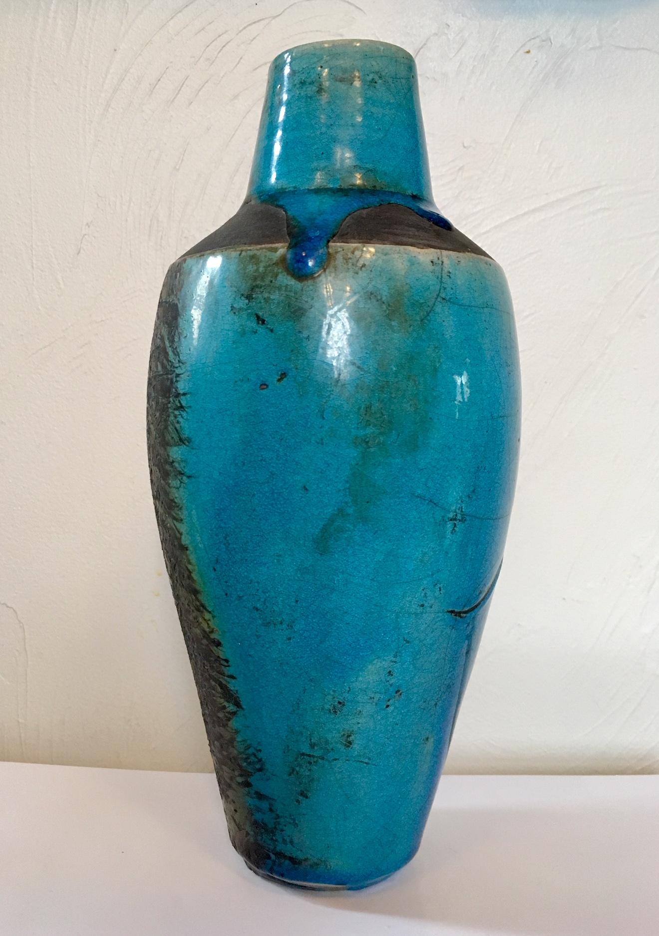 Art Studio ceramic vase, signed Jakob, circa 1980s. A hand thrown clay vase with short neck and narrow slanted shoulders above a tapering cylindrical bod; in a turquoise hue under clear crazed glaze, with black bisque shoulders, a black textured