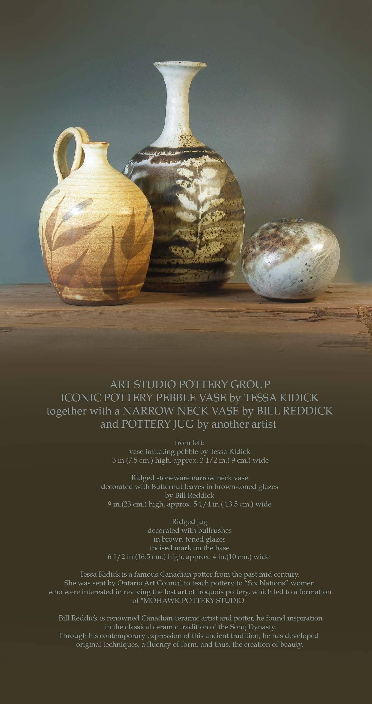 Art Studio Pottery group iconic pottery pebble vase by Tessa Kidick, together with a narrow neck vase by Bill Reddick and pottery jug by another artist.

From left: Vase imitating pebble by Tessa Kidick, measures 3
