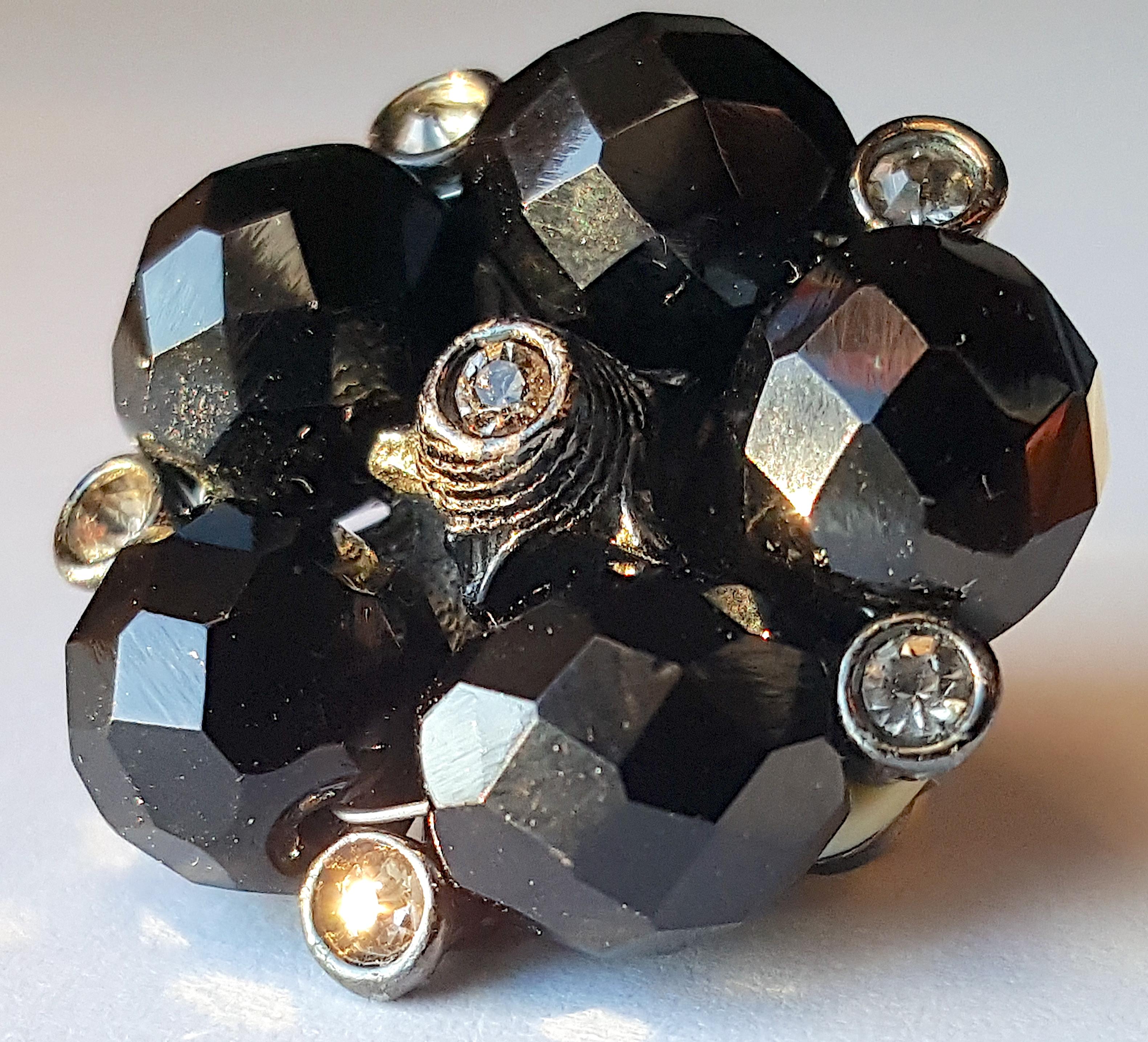 Featuring five sparkly black opaque spinels with diamond-shaped facets and splintery vitreous surfaces, along with bezel-set champagne diamonds with yellow or peach reflections in sunlight, these unsigned mid-century Buccellati-style