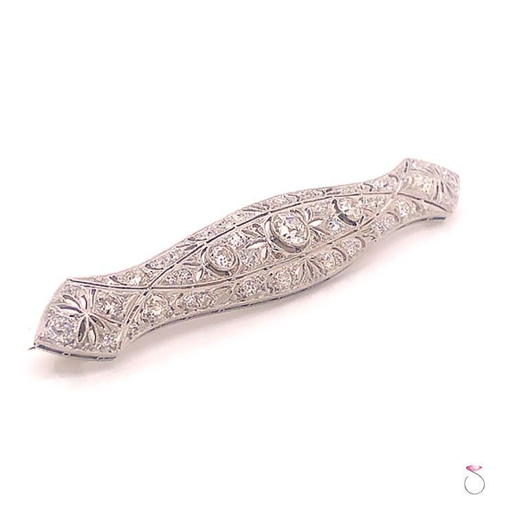 Art Deco Diamond brooch in platinum. Beautifully hand crafted in platinum with gorgeous details and mil-grain boarders. The center diamond and the two side diamonds are bezel set with mil-grain details on the bezels. The center diamond is