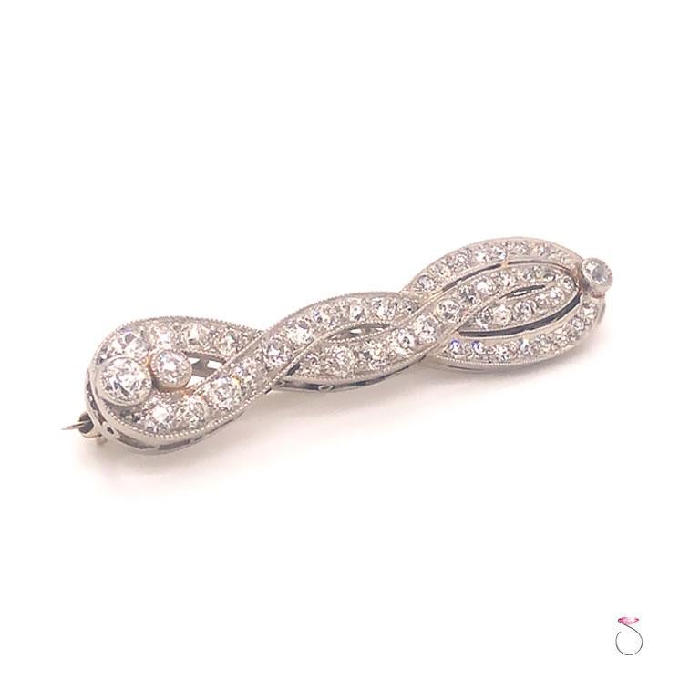 Art Deco Diamond Brooch in platinum. Gorgeous hand crafted art deco brooch in a braided infinity design. The brooch is set with 50 rounded European cut diamonds in various sizes, bead set with the three larger diamonds in bezel sets. The brooch also