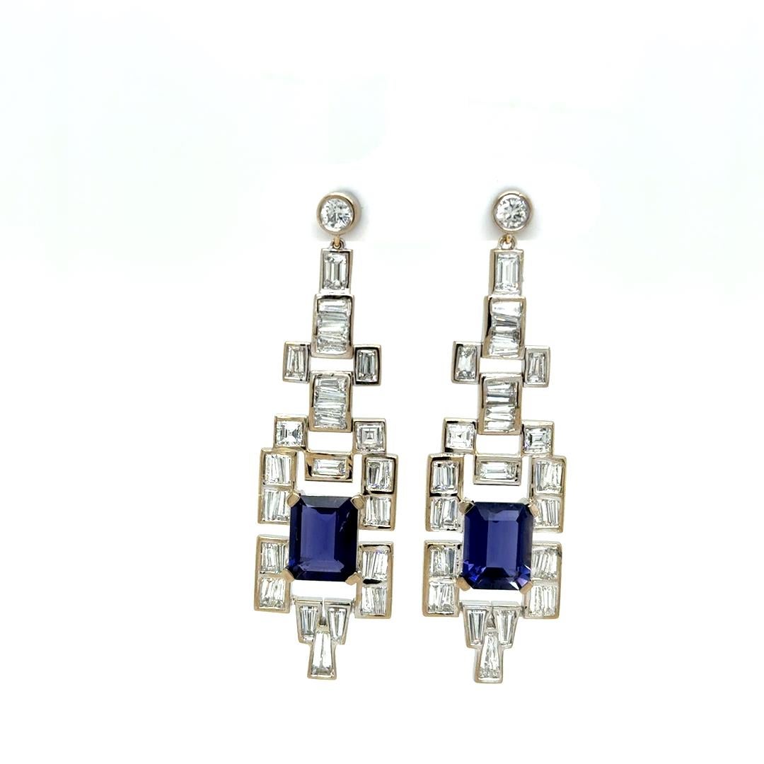 Inspired by the geometric elegance of the Art Deco era, these striking earrings are crafted in 18kt white gold, featuring a stunning emerald-cut deep blue iolites totaling 3.73 carats. Accented with 62 precisely set baguette diamonds weighing 2.48