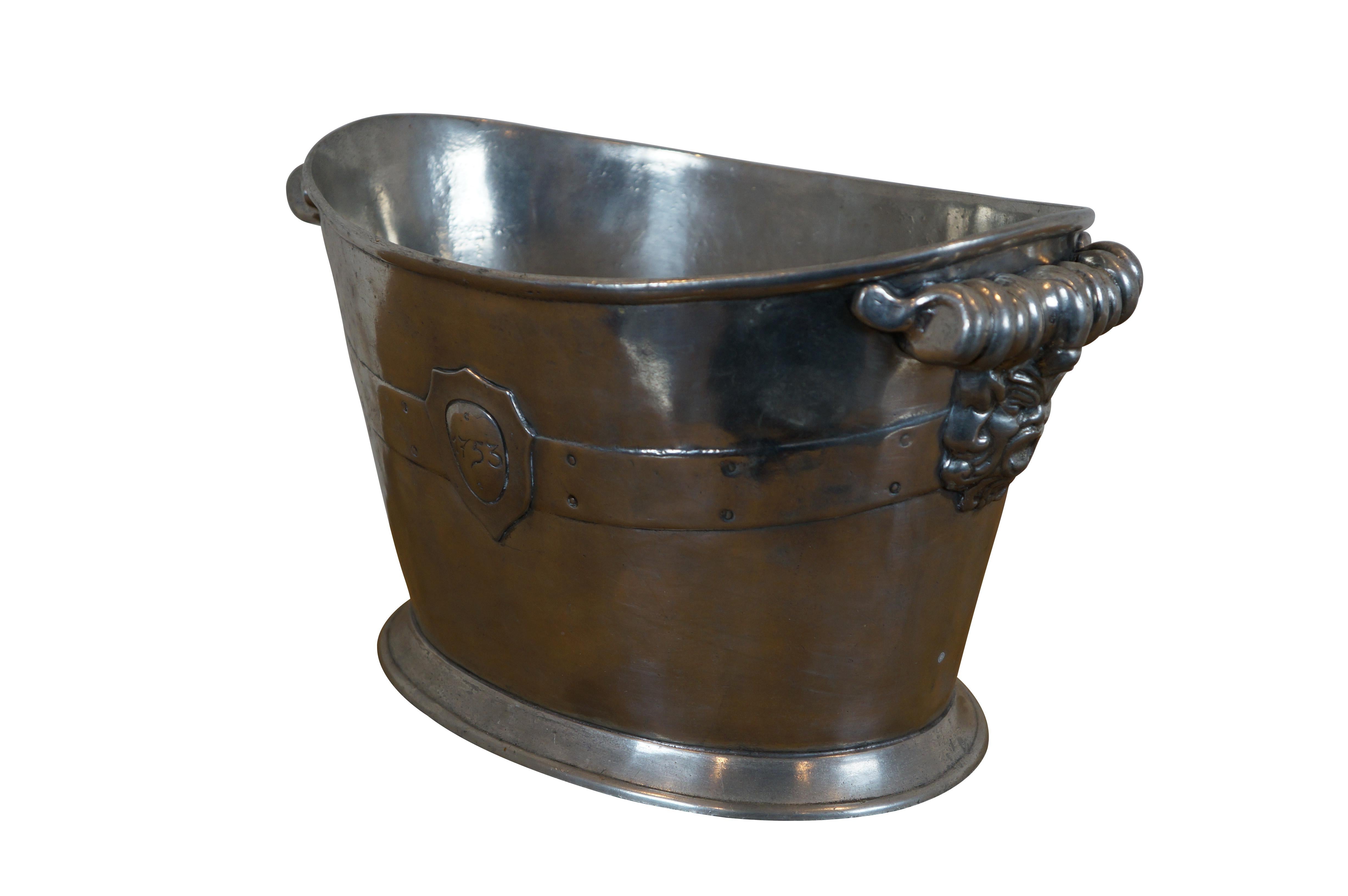 Late 20th century Arte Italica 95% Pewter ice bucket / champagne chiller. Oval-footed bucket shape cast with a decorative band accented with a heraldic crest / shield marked 1753 and a pair of spiral handles over an open face, likely depicting