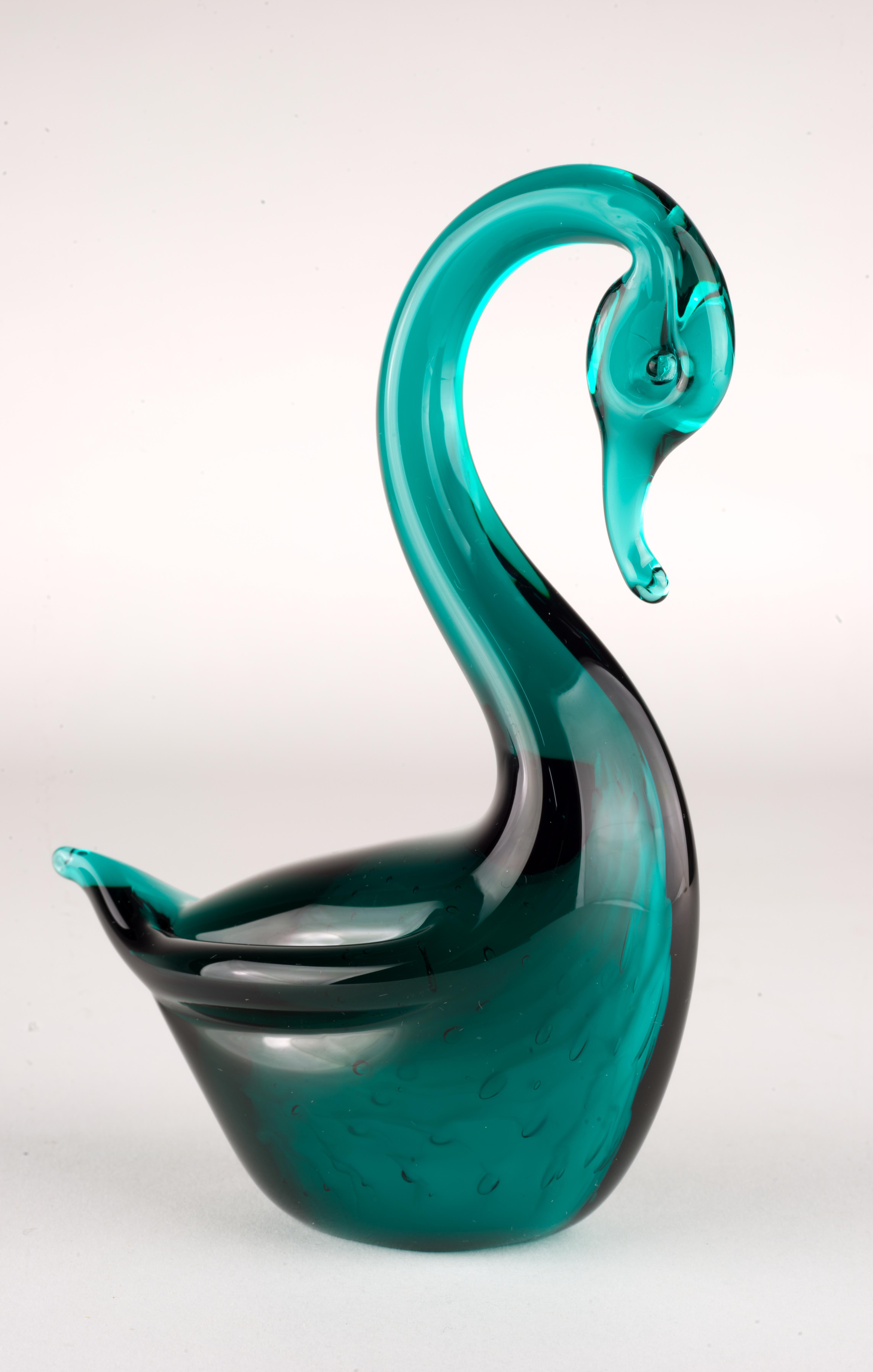 Murano glass swan figurine or paperweight is made of white glass encased inside dark green glass in sommerso technique; controlled bubbles are used throughout the body of the swan.