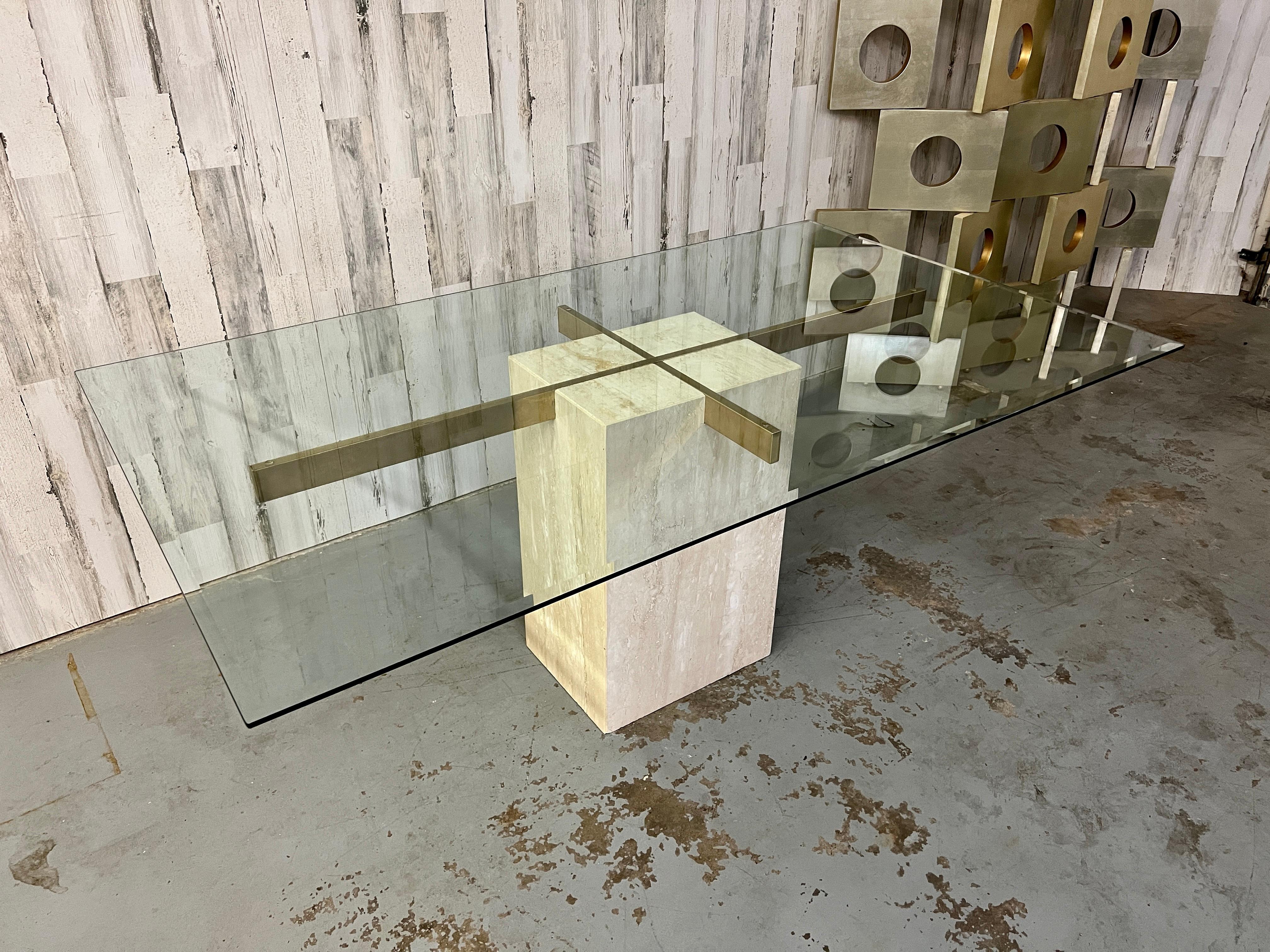 Cube en travertin avec motif de croix en laiton qui soutient le plateau en verre biseauté.