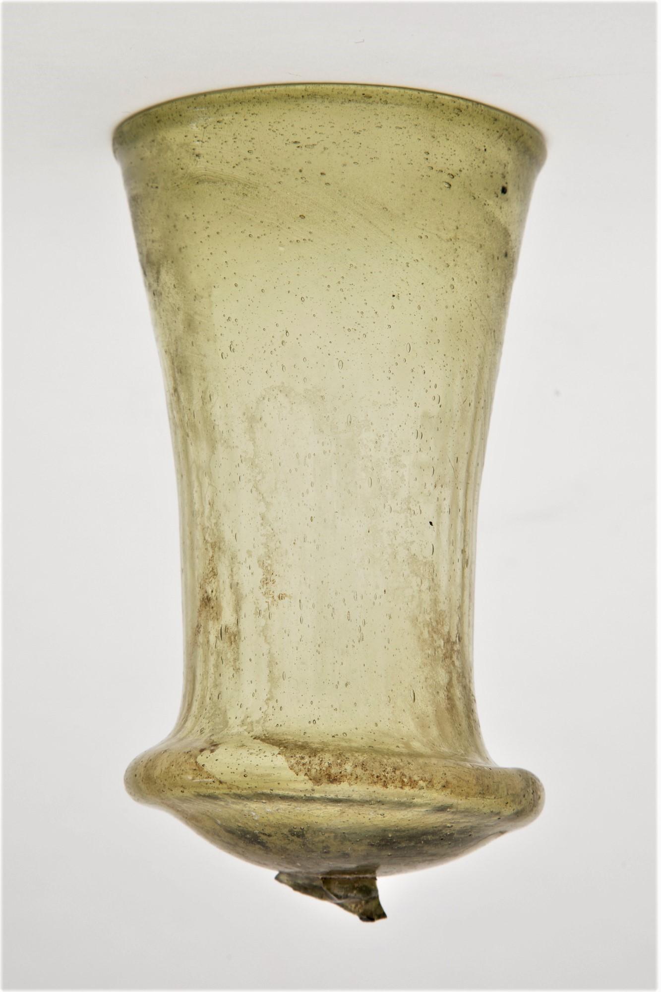 Late Roman Merovingian Glass Bell Beaker secular art from the Country: Germany / Krefeld. Culture: Merovingian.Date: 6th century AD.Material: Pale yellow, pattern molded, transparent glass. Decorated with thin vertical ribs. Conical in form with