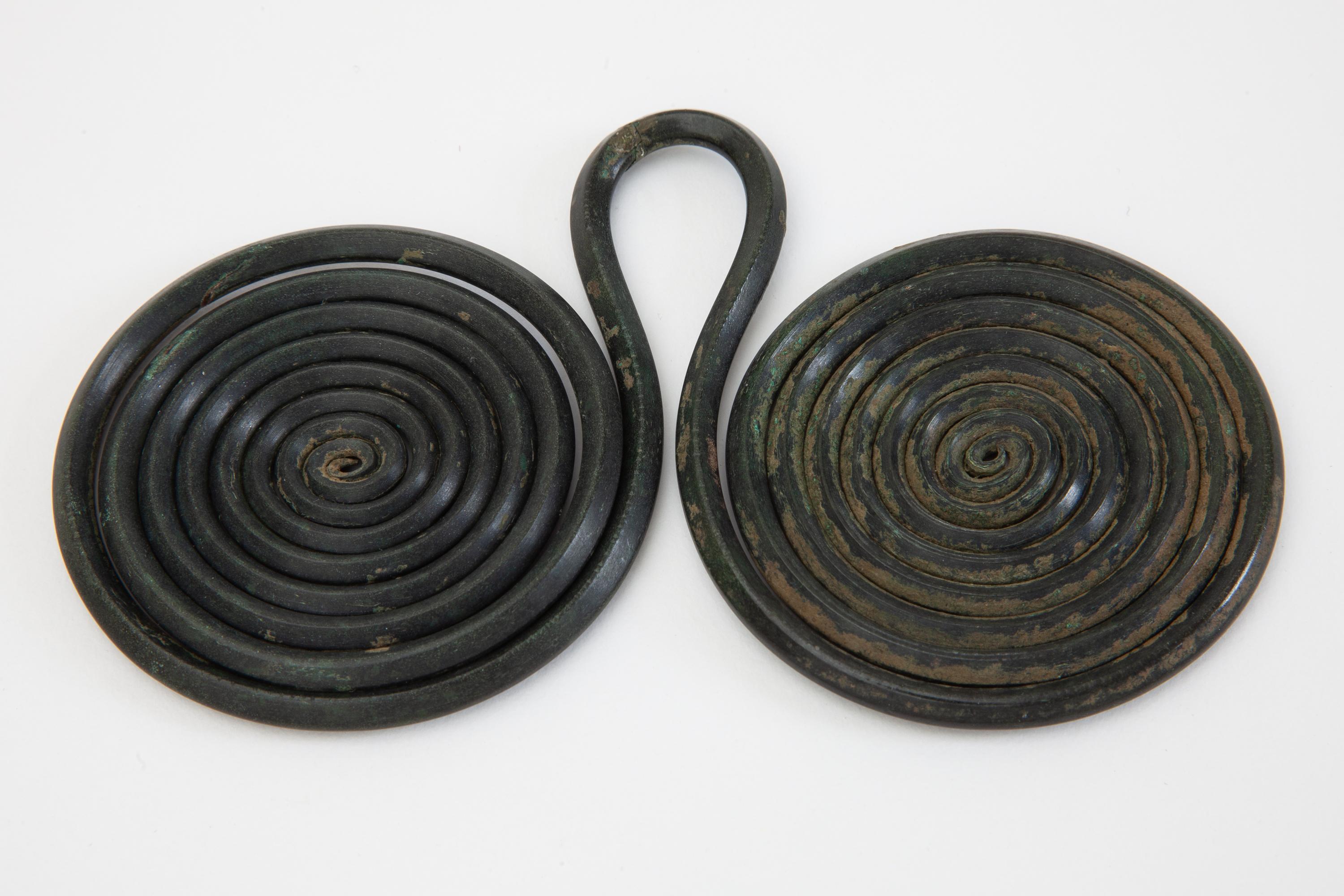 Ancient bronze age spectacle brooch, fibula or fastener from an ancient Austrian collection.
A composition of two concentrically wound copper alloy spirals coils with a loop in the centre.
Authentic well preserved patina of age.
Lit: Goldmann,