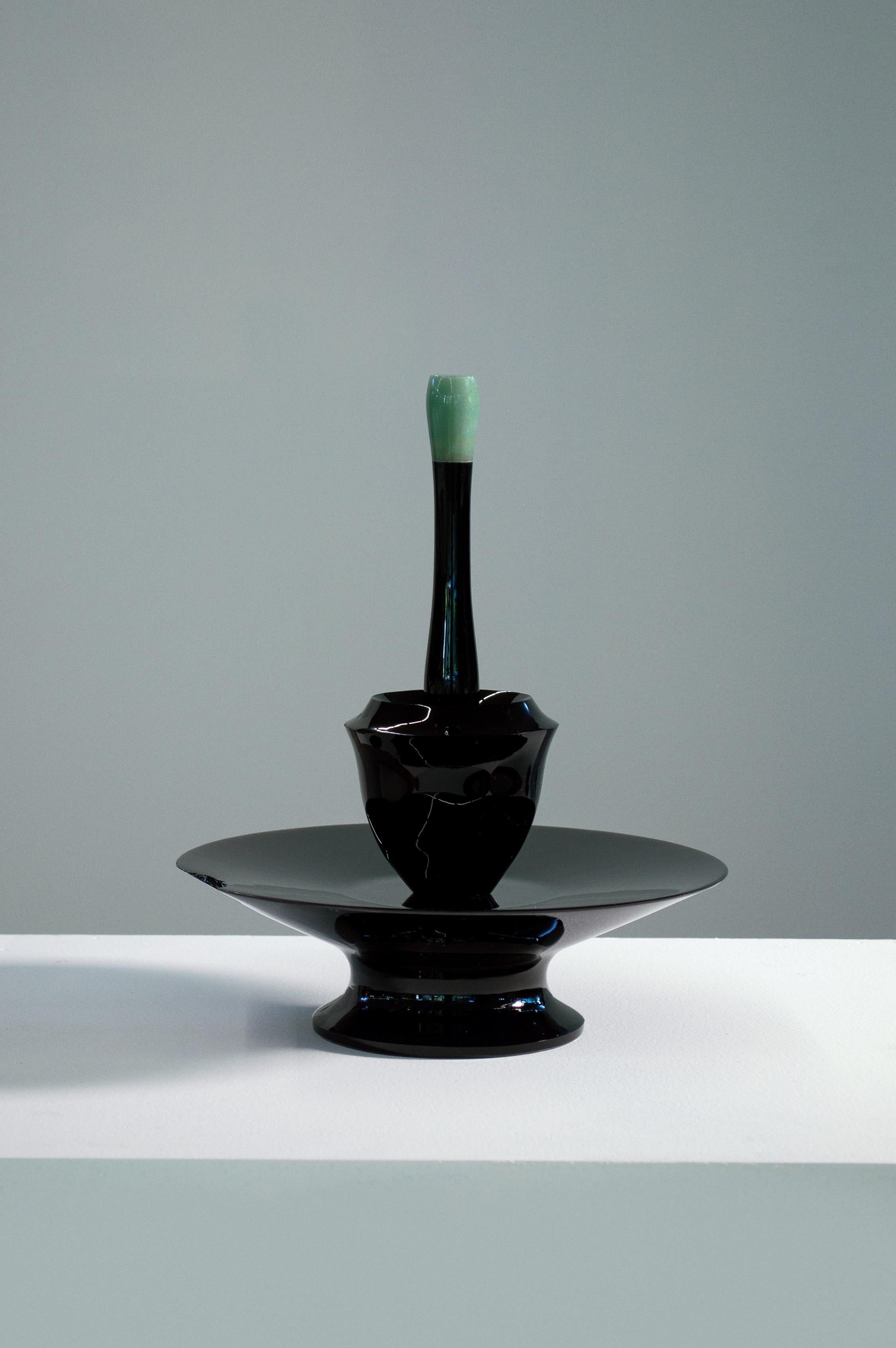 Artefacto C.002.002 sculpture by Acoocooro
Dimensions: ø 27 x H 30 cm.
Materials: Turned obsidian and aventurine (green quartz).
Limited edition.

Artefacto C.002.002, more than any possible exploration of either concept or aesthetics, is a