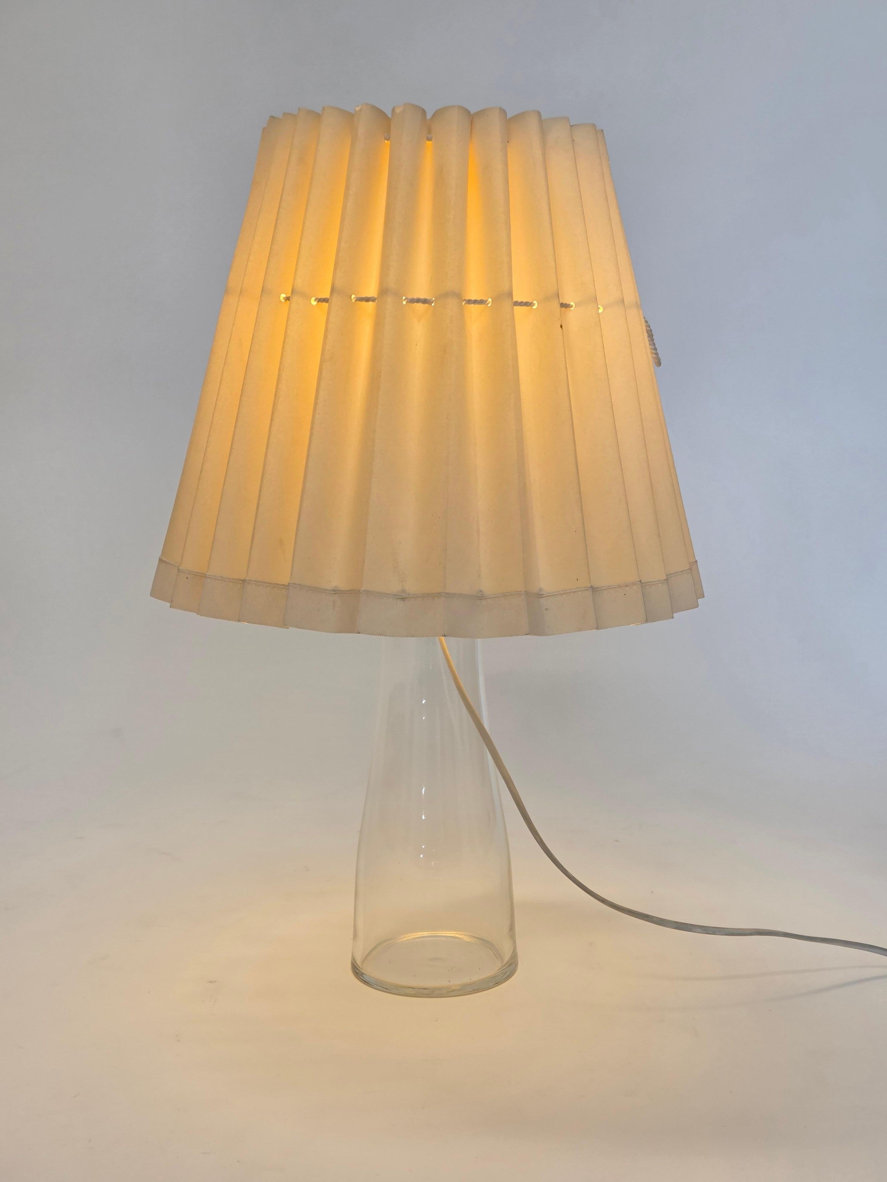 Lampe de table modèle M510, conçue par Maire Gullichsen et fabriquée par Artek en Finlande. Base en verre transparent, collier en laiton et abat-jour en papier blanc. La base est en très bon état d'usage. Quelques déchirures et taches sur