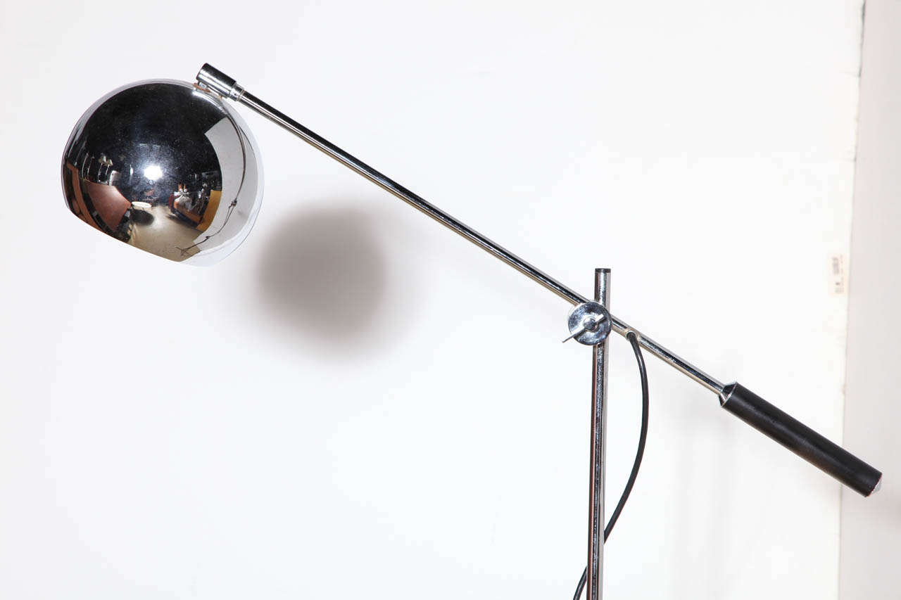 Articulating Arteluce style chrome, black enamel and leather handle tripod reading floor lamp, 1960's. In the manner of Gino Sarfatti. Featuring a counter balance single arm, chrome and black enamel column, wrapped black leather handle, 7D chrome