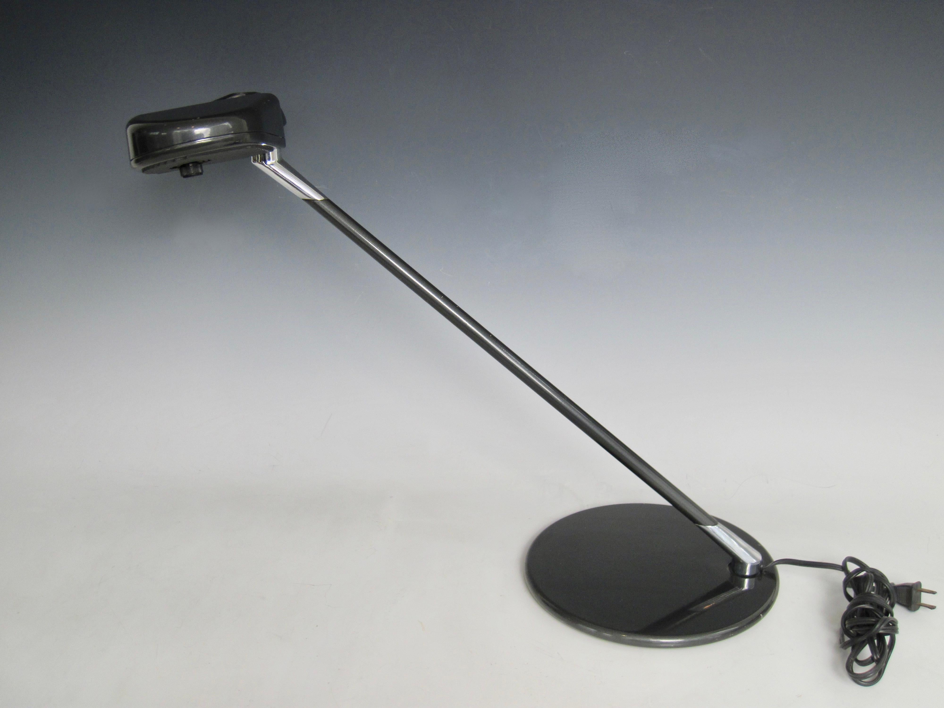 A Ring A 400 Halogen-Tischleuchte, entworfen von Bruno Gecchelin für Arteluce.  Die dunkelgrau lackierte Schreibtischlampe aus gewichtetem Metall hat einen schwenkbaren Kopf für die Beleuchtung von Aufgaben. Der tragende Reflektorkopf hält den