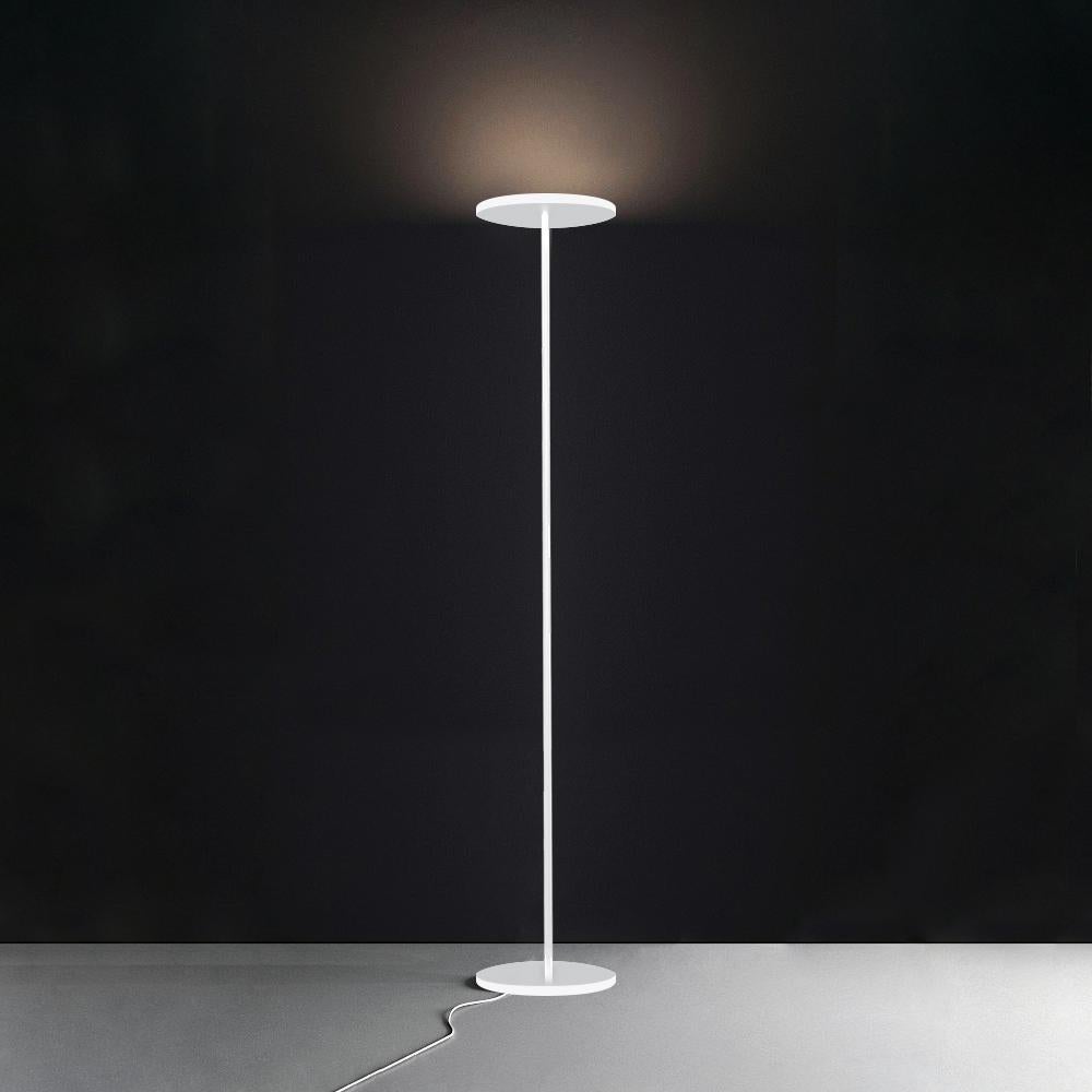 A floor lamp with indirect diffused emission, whose minimal footprint is the main feature of the project. 

Two identical thin discs at the base and top are connected by a slender tubular stem. 

Its minimal elegance makes this piece a timeless