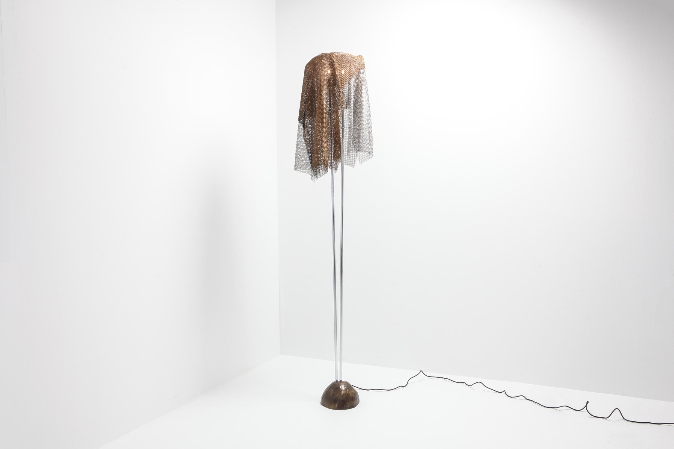 Unusual Postmodern floor lamp in bronze, chromed steel and chain mail.
by Toni Cordero for Artemide
Fits well in an eclectic Hollywood Regency Grace Jones style grotto interior.


 