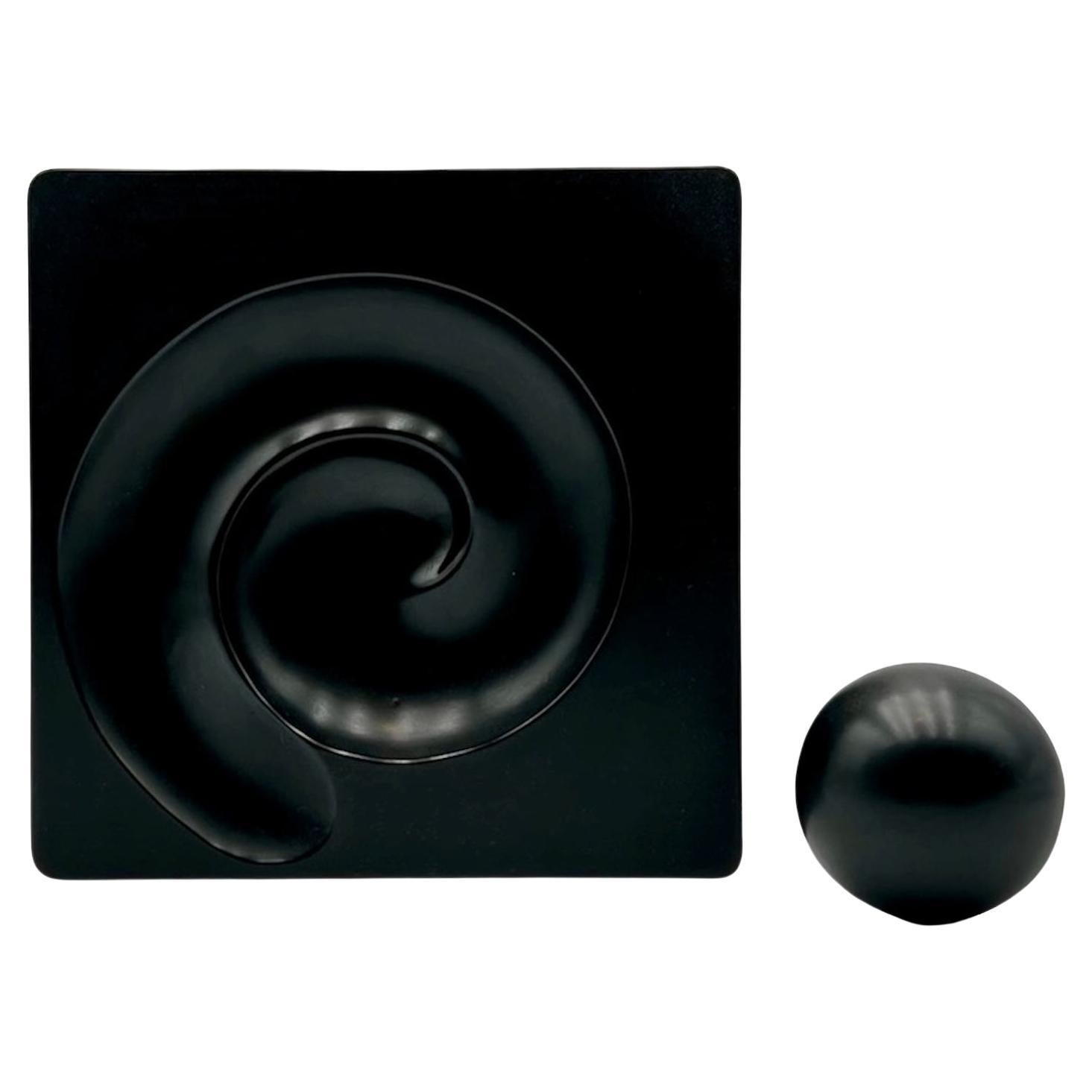 Iconic and ultra rare melamine sculpture Spyros by Artemide. Designed by Eleanor Peduzzi Riva in 1976 and conceived as a table ashtray, Spyros features a heavy black sphere that slides gently in the groove. 

The base was available in different