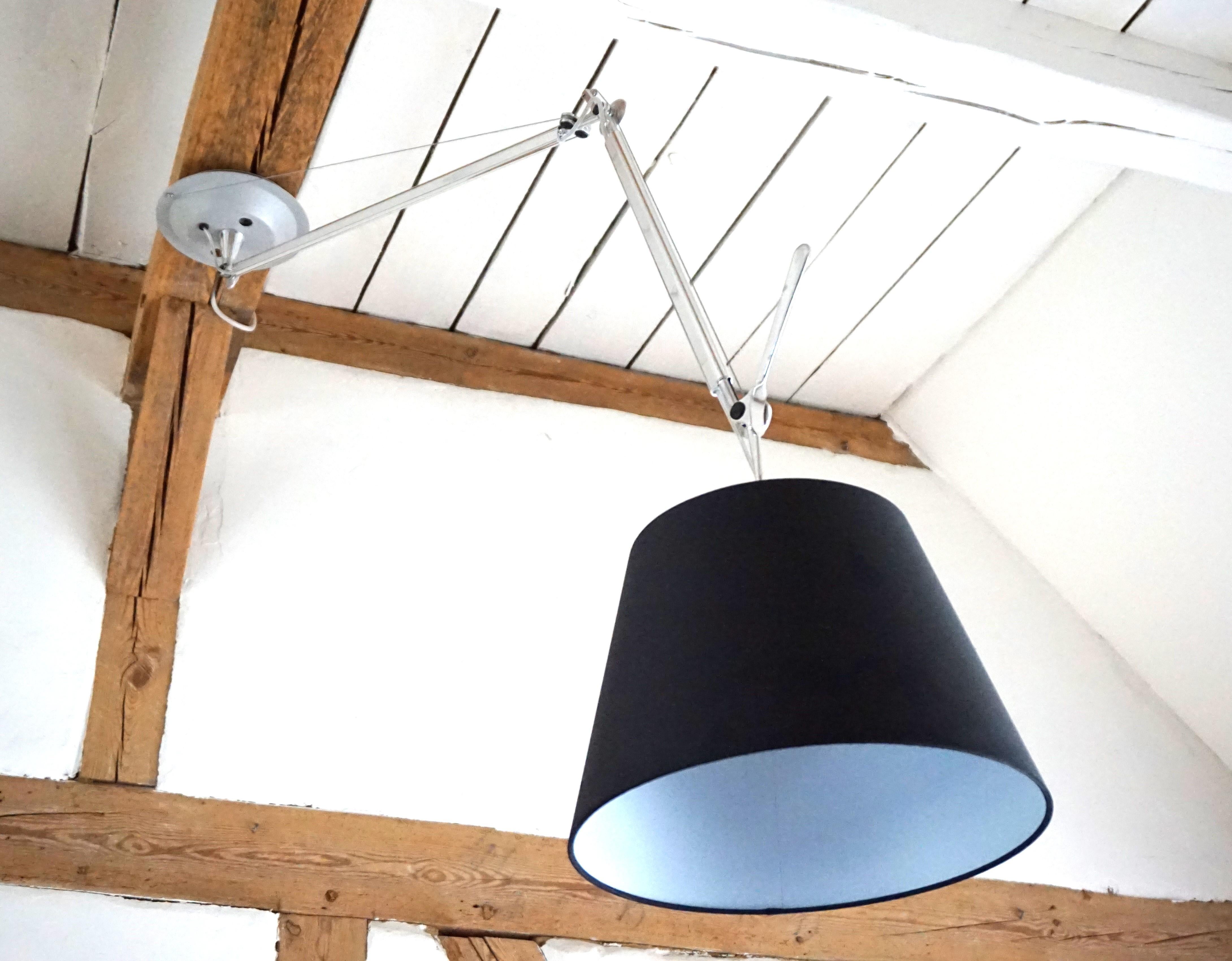 Questa lampada a sospensione Tolomeo in cromo e grande paralume nero con diametro di 32 cm è in ottime condizioni. La funzione di rotazione della lampada intorno al proprio asse e il meccanismo a molla per regolare l'inclinazione e l'altezza della