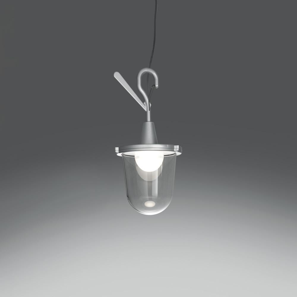 Die Tolomeo-Familie wird um ein neues Outdoor-Produkt erweitert. Die Lichtquelle ist von einer Streukappe umgeben, die sich in einem transparenten Kunststoffgehäuse (IP65) befindet, das an alte Laternenmasten erinnert, die verwendet wurden, als das