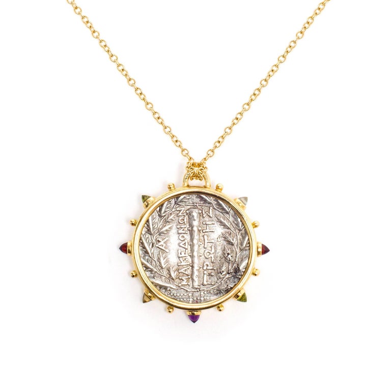 This DUBINI coin necklace from the 'Empires' collection features an authentic Macedon coin from 168-148 B.C. set in 18K yellow gold with bullet amethyst, garnet, topaz, citrine and peridot cabochons. 

Depicted on the coin: Macedonian shield with