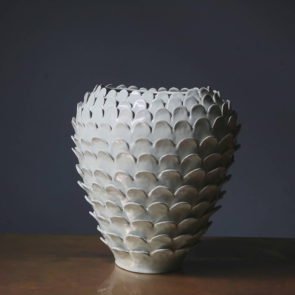 Elegant yet simple, this terracotta vase reveals its origin in the rustic hand-carved design, which was obtained using the colombino technique, an ancient coiling method used to produce fine handmade ceramic pieces. The raised fish scale pattern