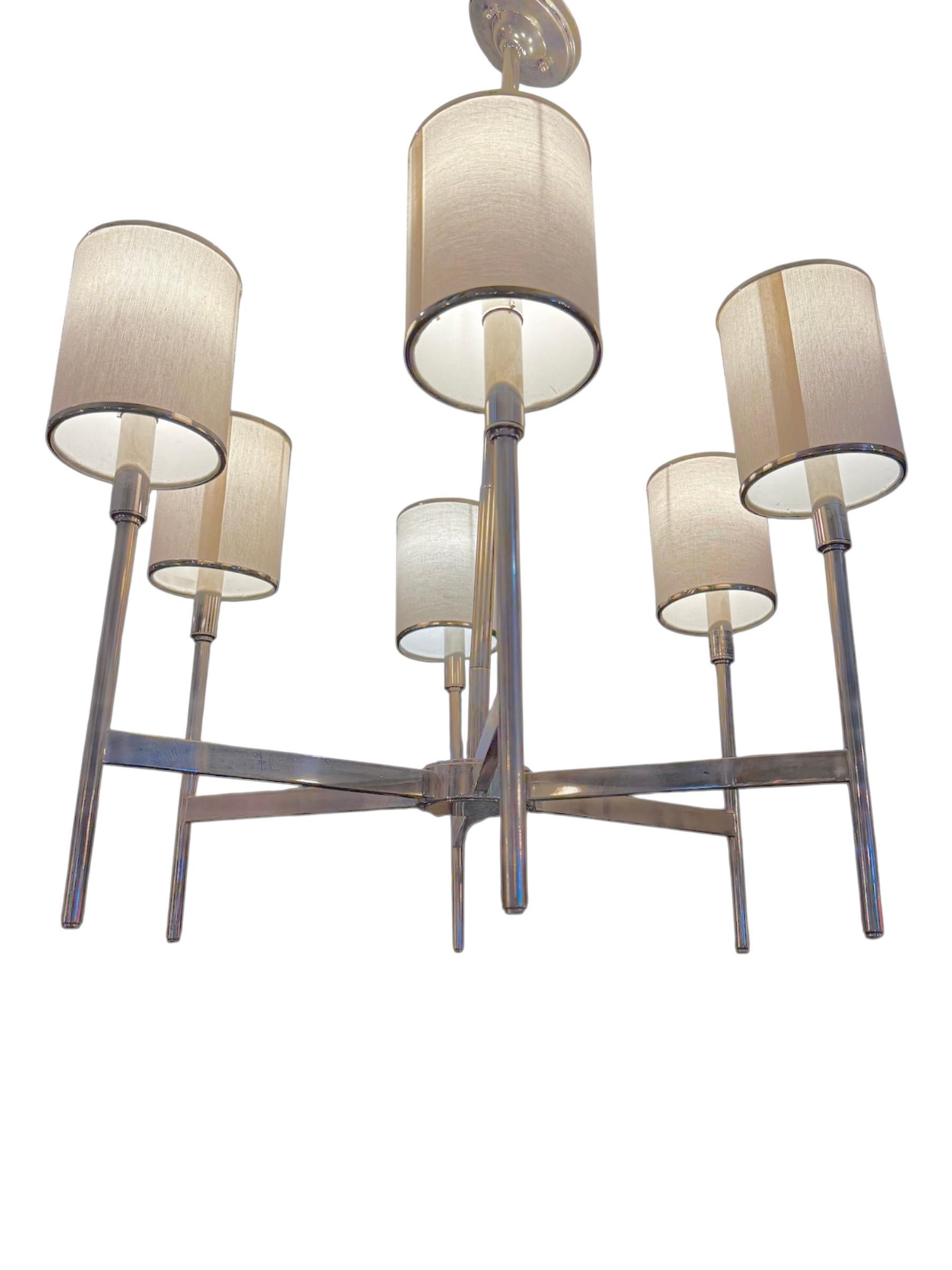 Bring a sleek, architectural elegance to your space with the Arteriors Remington Chandelier. Designed with clean, contemporary lines, this statement fixture features five evenly spaced arms finished in polished silver, each topped with a cylindrical