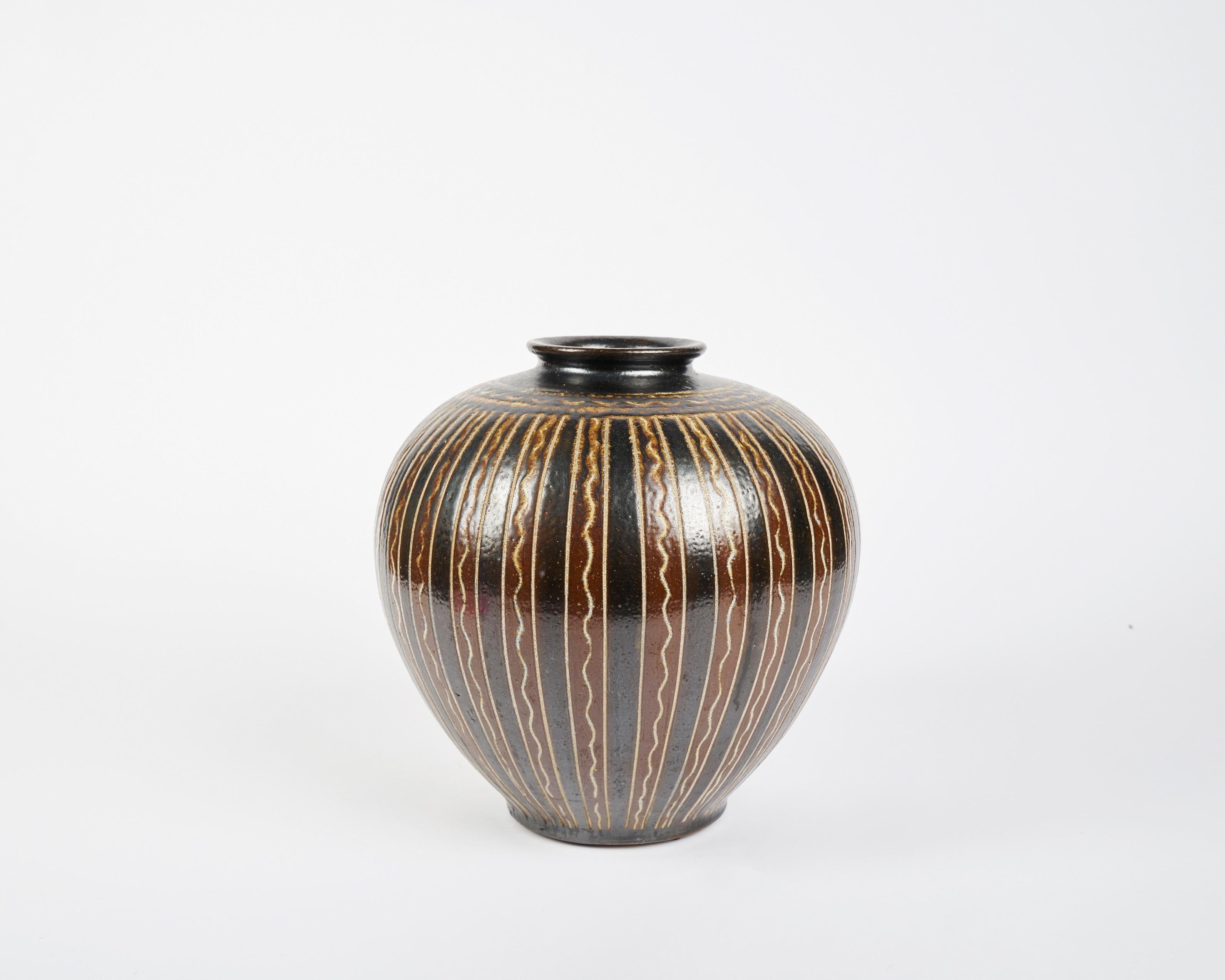 Created by the Swedish ceramist Arthur Andersson in the middle of the 20th century, these voluminous vases are noteworthy for their formal symmetry and their banded designs, which often run in either horizontal or vertical patterns of zig zag,