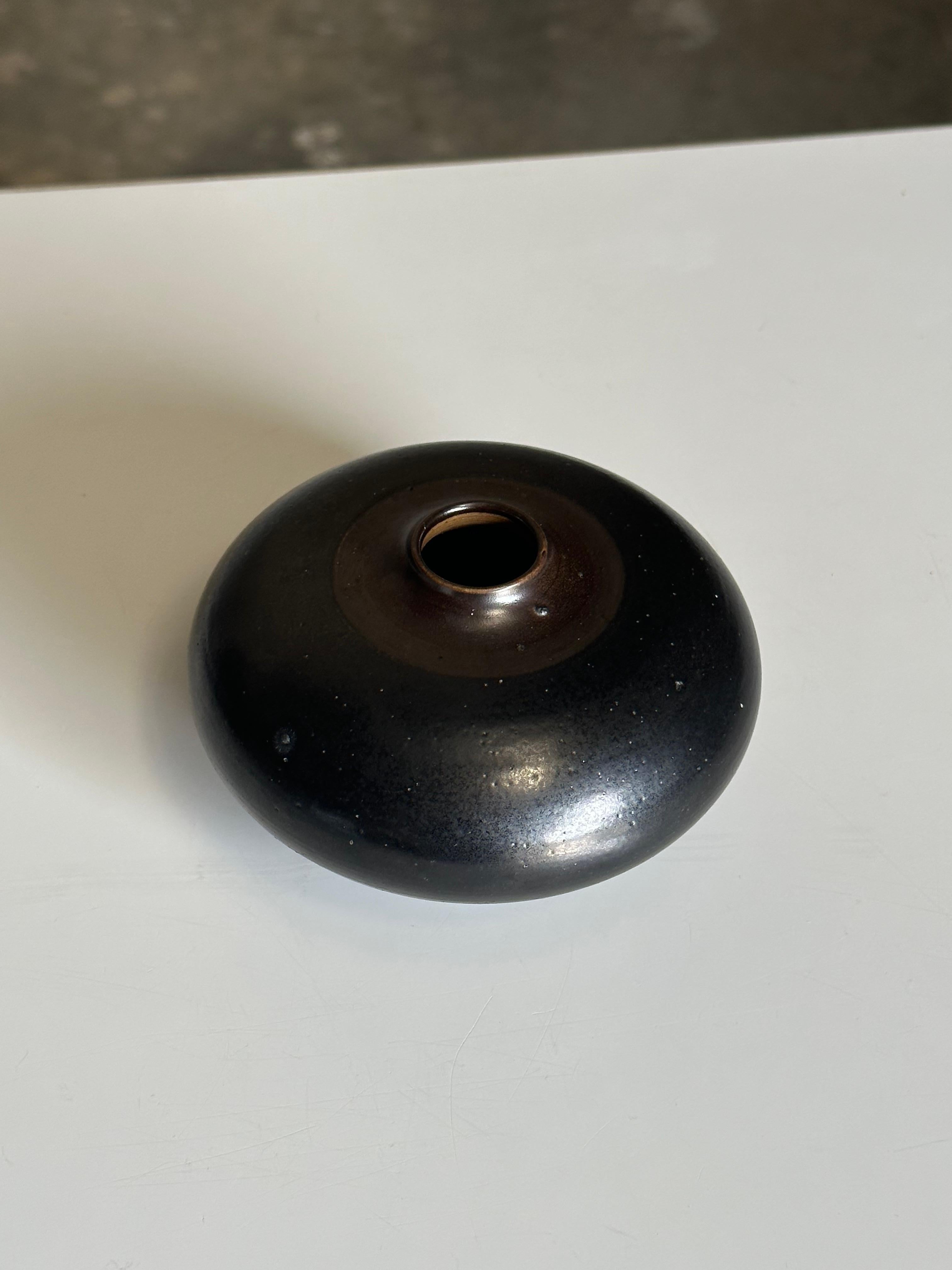 Vase aus Steingut, entworfen von Arthur Andersson für Wallåkra, ca. 1950er Jahre. Die aufregende Glasur beginnt als raues, flaches Schwarz am Boden und geht in ein glasiertes Schwarz mit etwas dunklem Braun am Rand über. Sehr schweres, gut