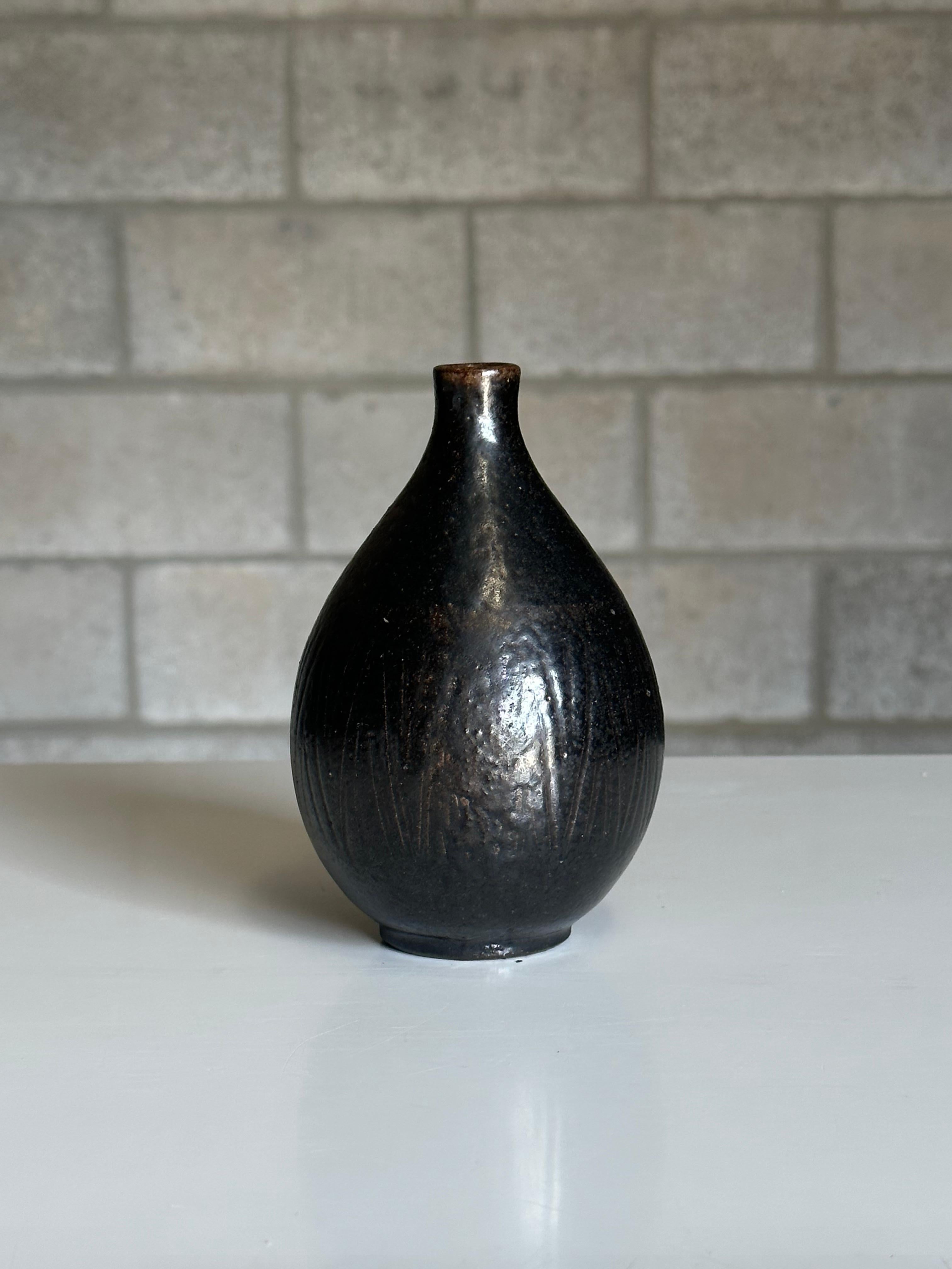 A stoneware vase designed by Arthur Andersson for Wallåkra, circa 1950s. Features an exciting black and brown dark glaze with incision pattern. Very heavy well made piece in an elegant tear drop form. 