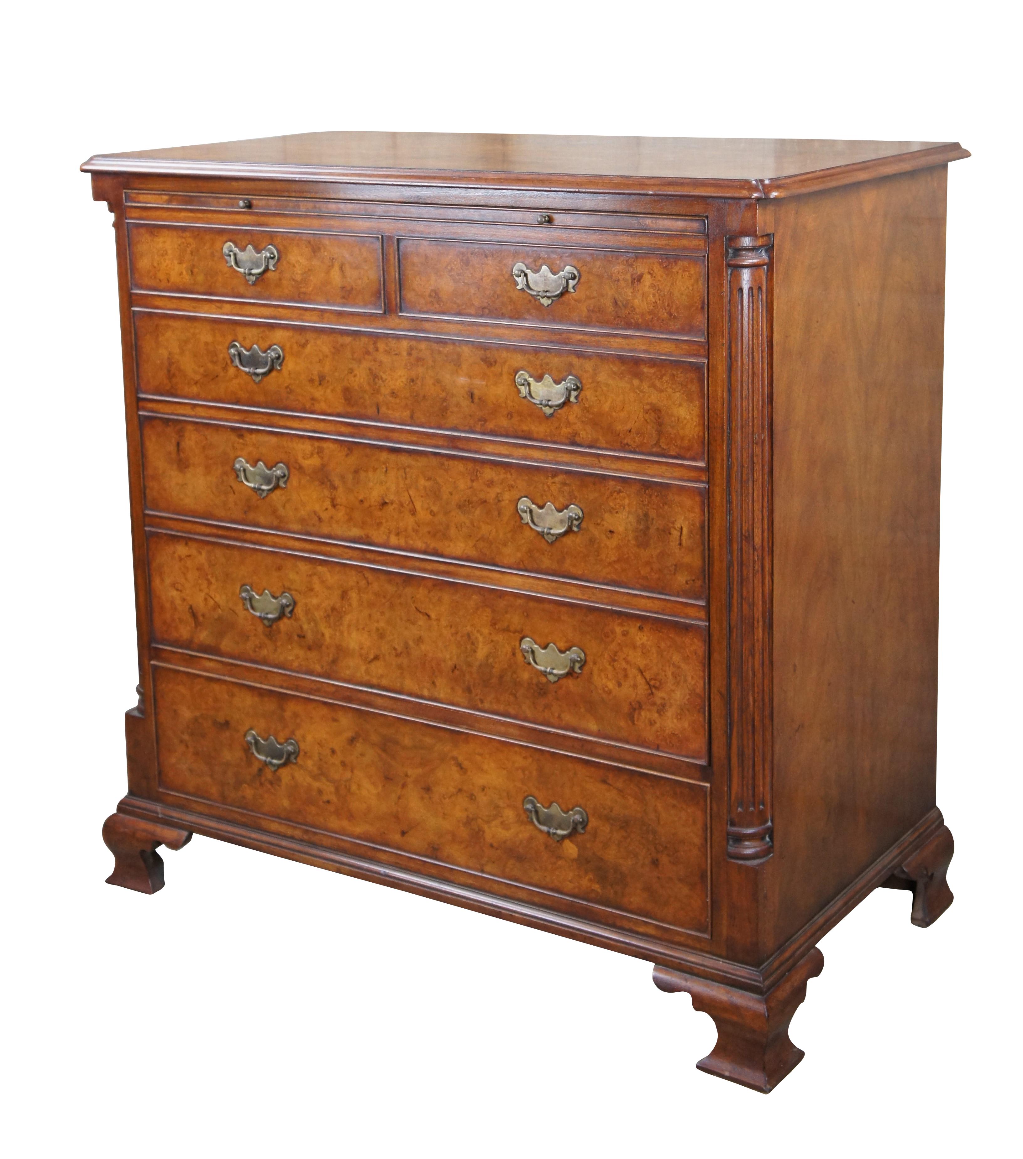 An exquisite 18th Century reproduction in the form of a bachelors chest by Arthur Brett & Sons. Made from mahogany with burled front and top. Features a faux 2 over 4 drawer graduated design which draws forward and slides back to reveal an interior